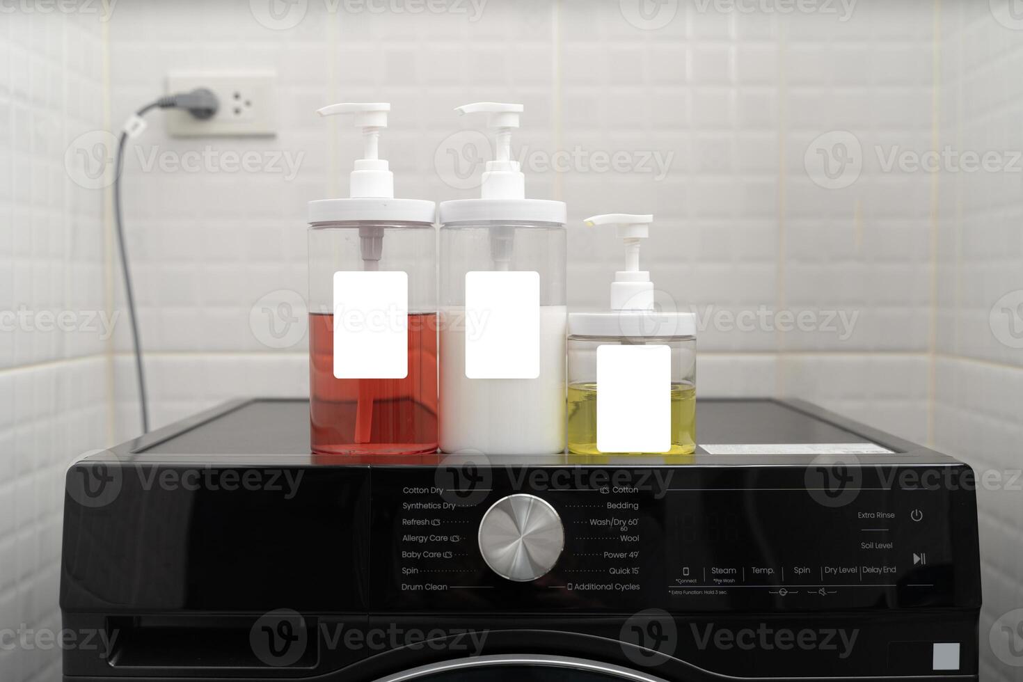 Set of colorful liquid detergent bottles with pump on washing machine for laundry cleaning household chores photo