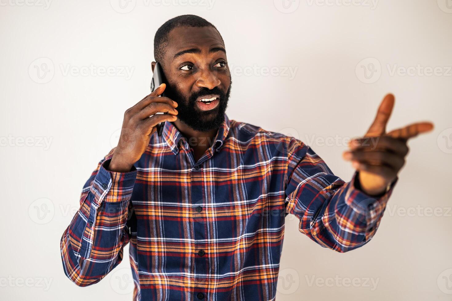 Handsome African American male in his 30s looking away with a satisfied smile as he communicates on his mobile phone. photo