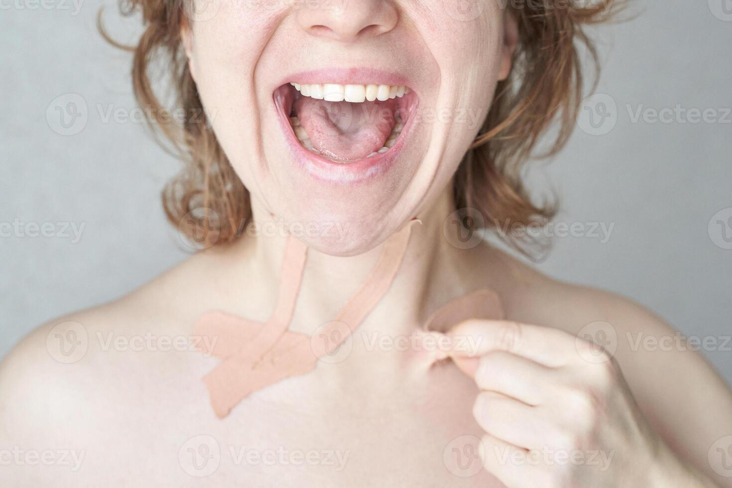 Female removing neck tape for skin care with a happy expression. photo