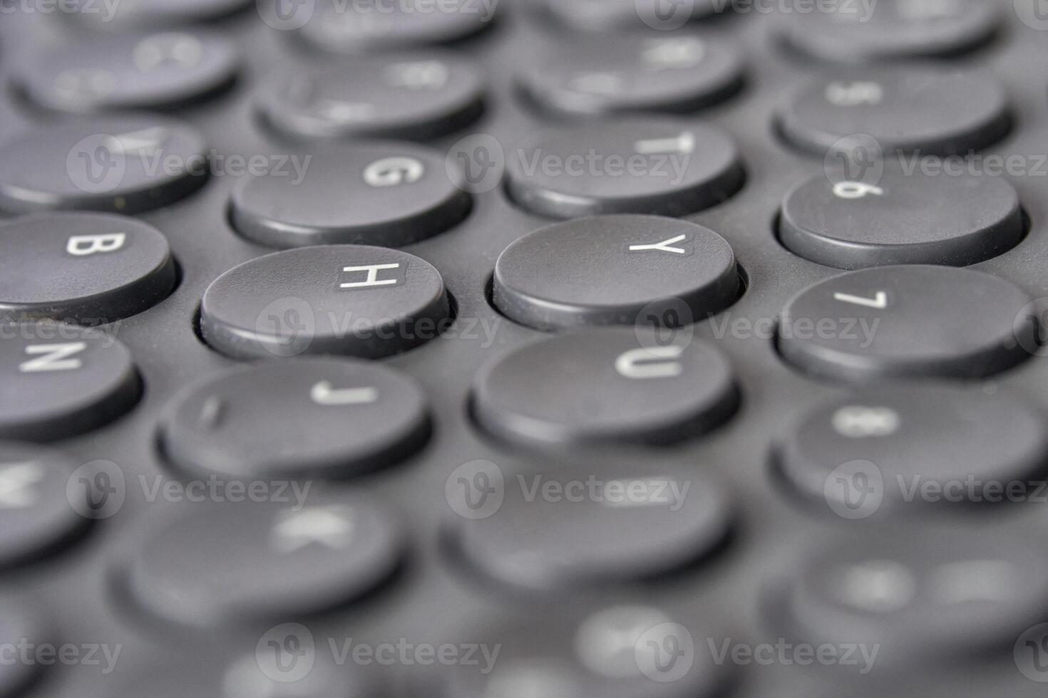 Close up of black round keyboard keys with alphabet and numerals. photo