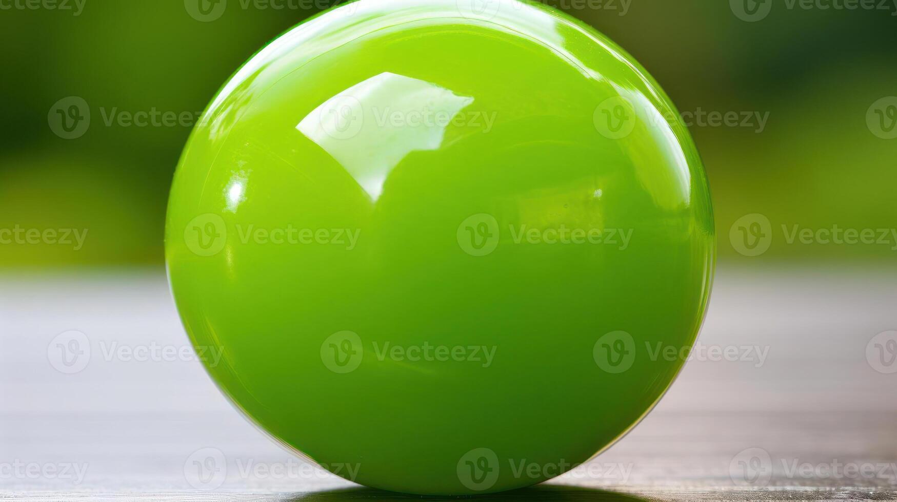 A vibrant green ball reflecting light on a surface. photo