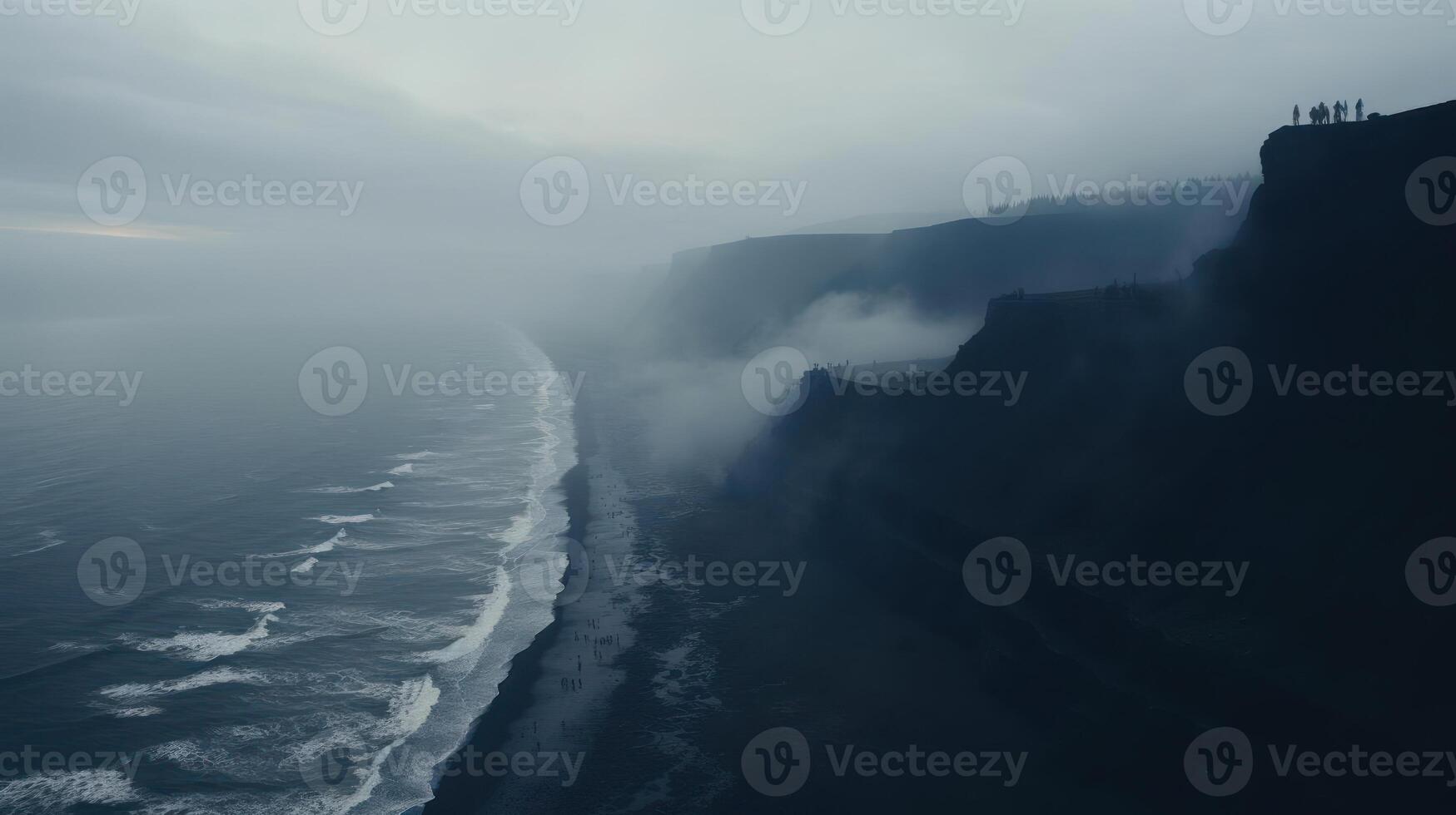 Dramatic cliffs meet the sea under a misty veil. photo