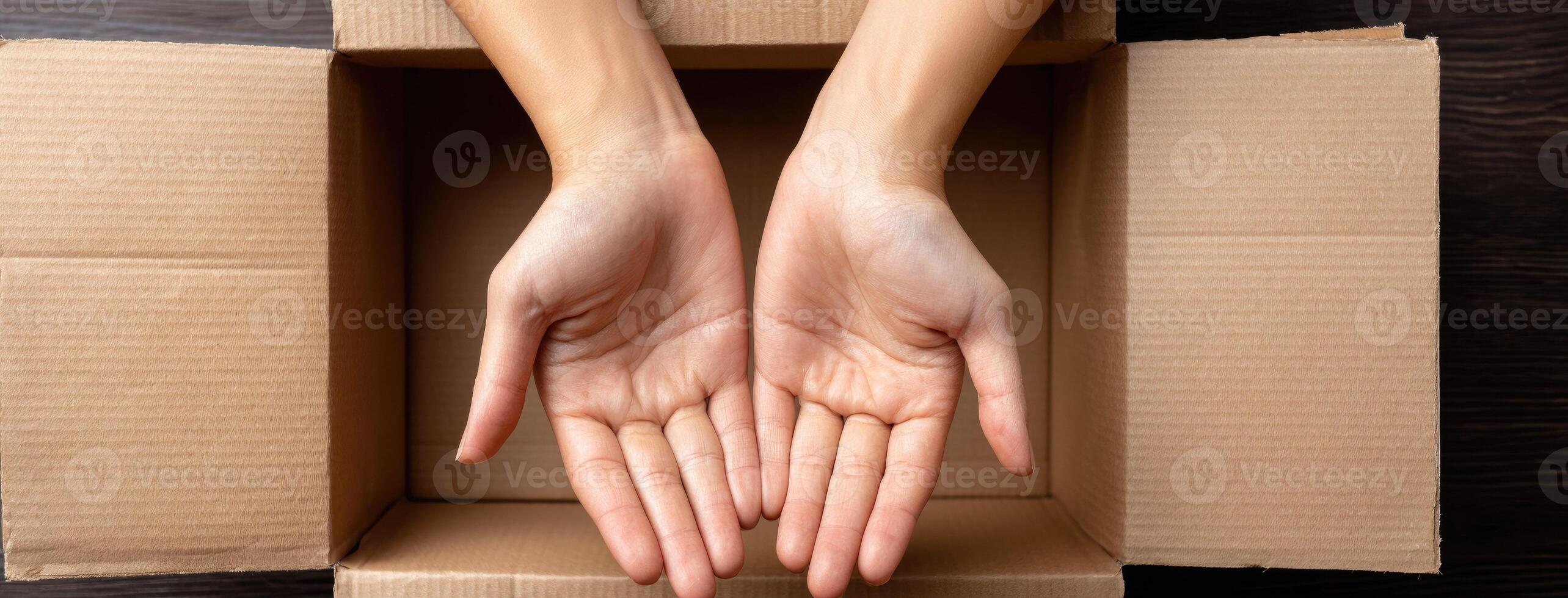 Two hands are holding out a box on a wooden table photo
