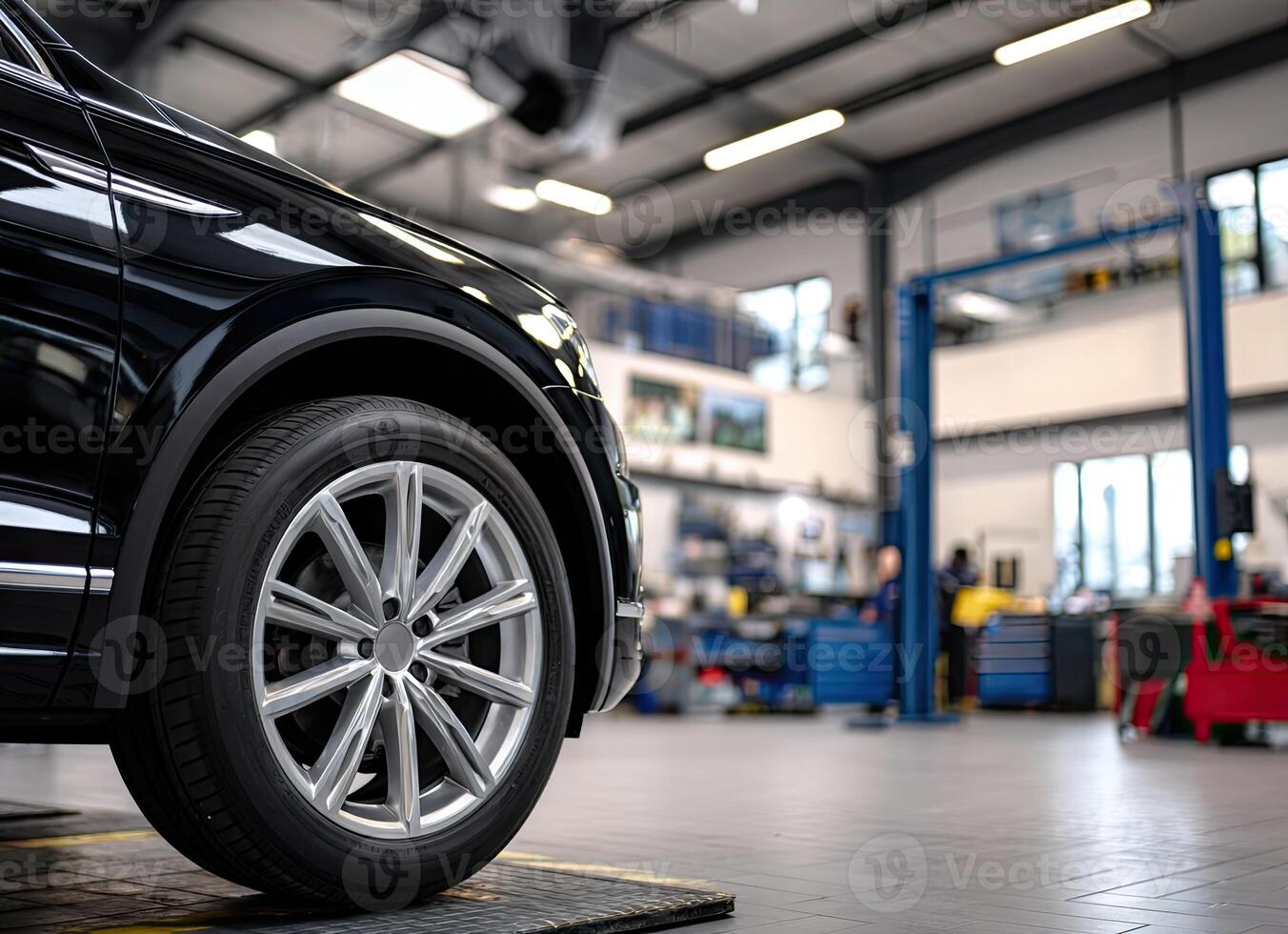 A black car is on a lift in a garage photo