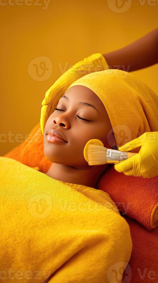 A woman getting a facial treatment with a yellow towel photo