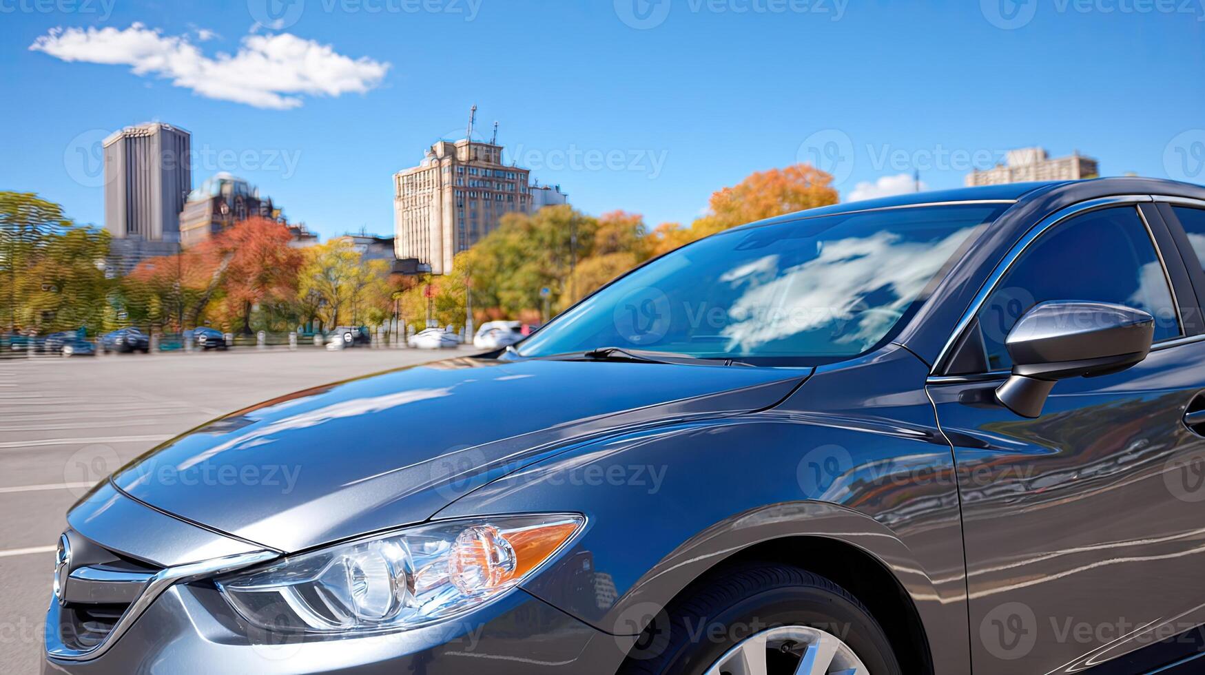 A car is parked in a parking lot with a city in the background photo