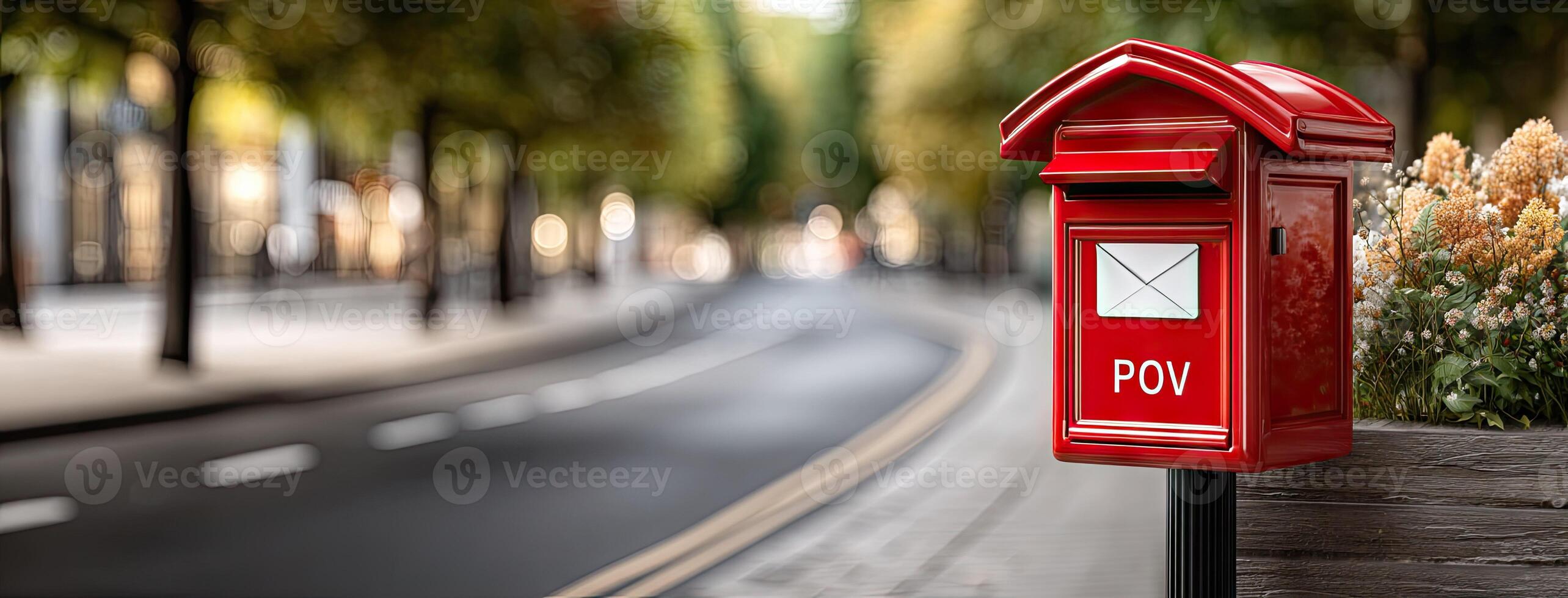 A red post box is sitting on the side of a street photo