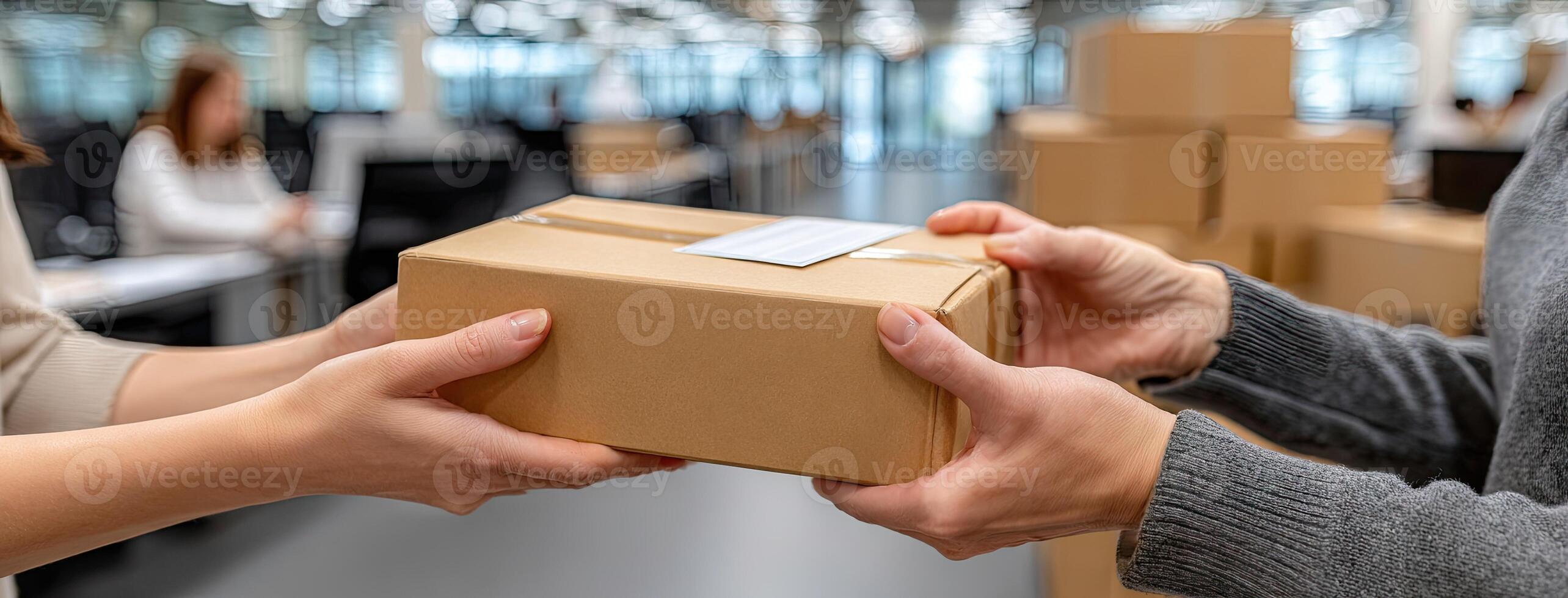 A man handing a package to another person in an office photo
