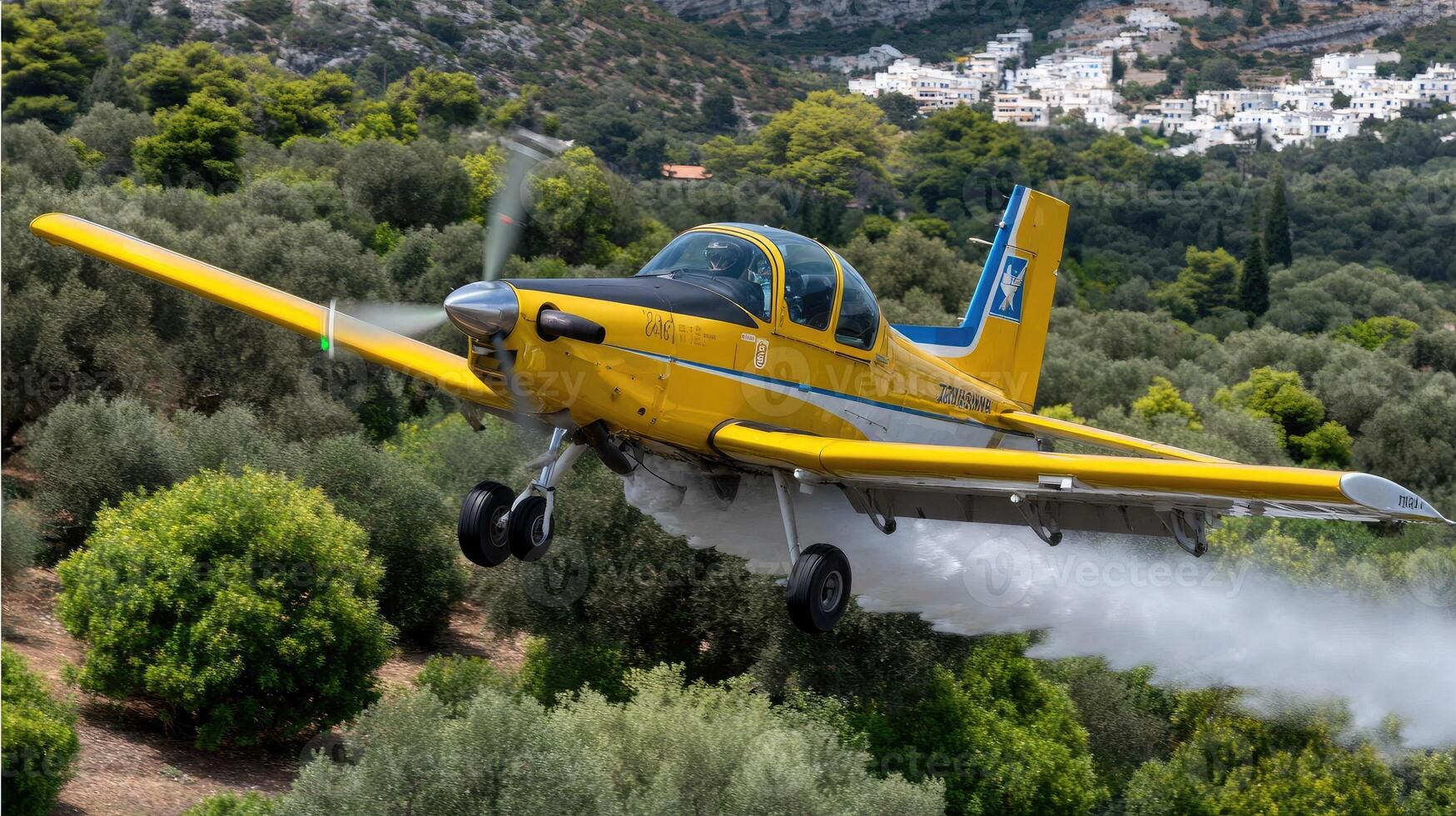 A small airplane is spraying water on a hillside photo