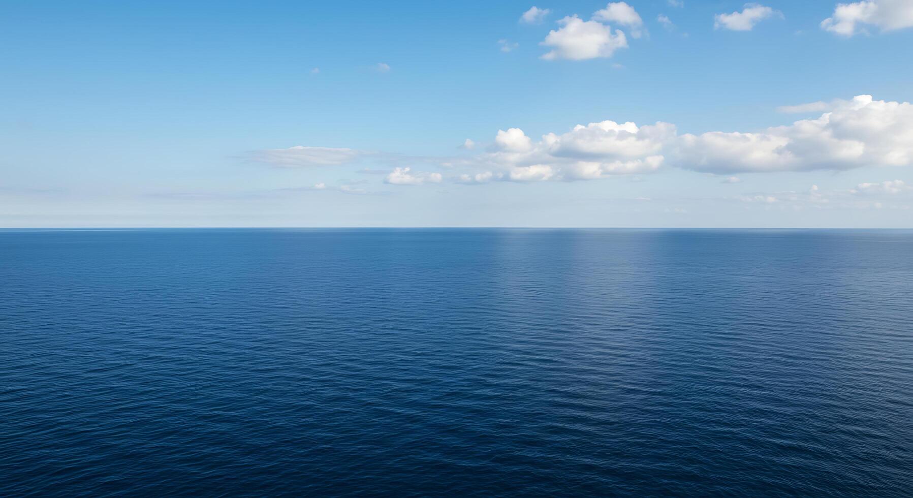 A large body of water with a few clouds photo