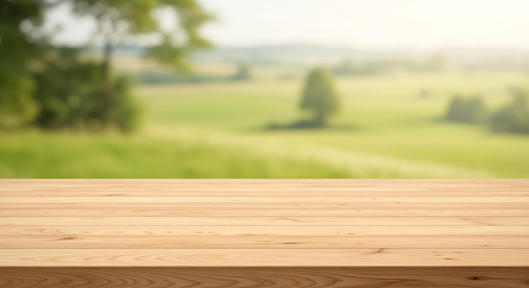 Empty wooden table top over blurred green field photo