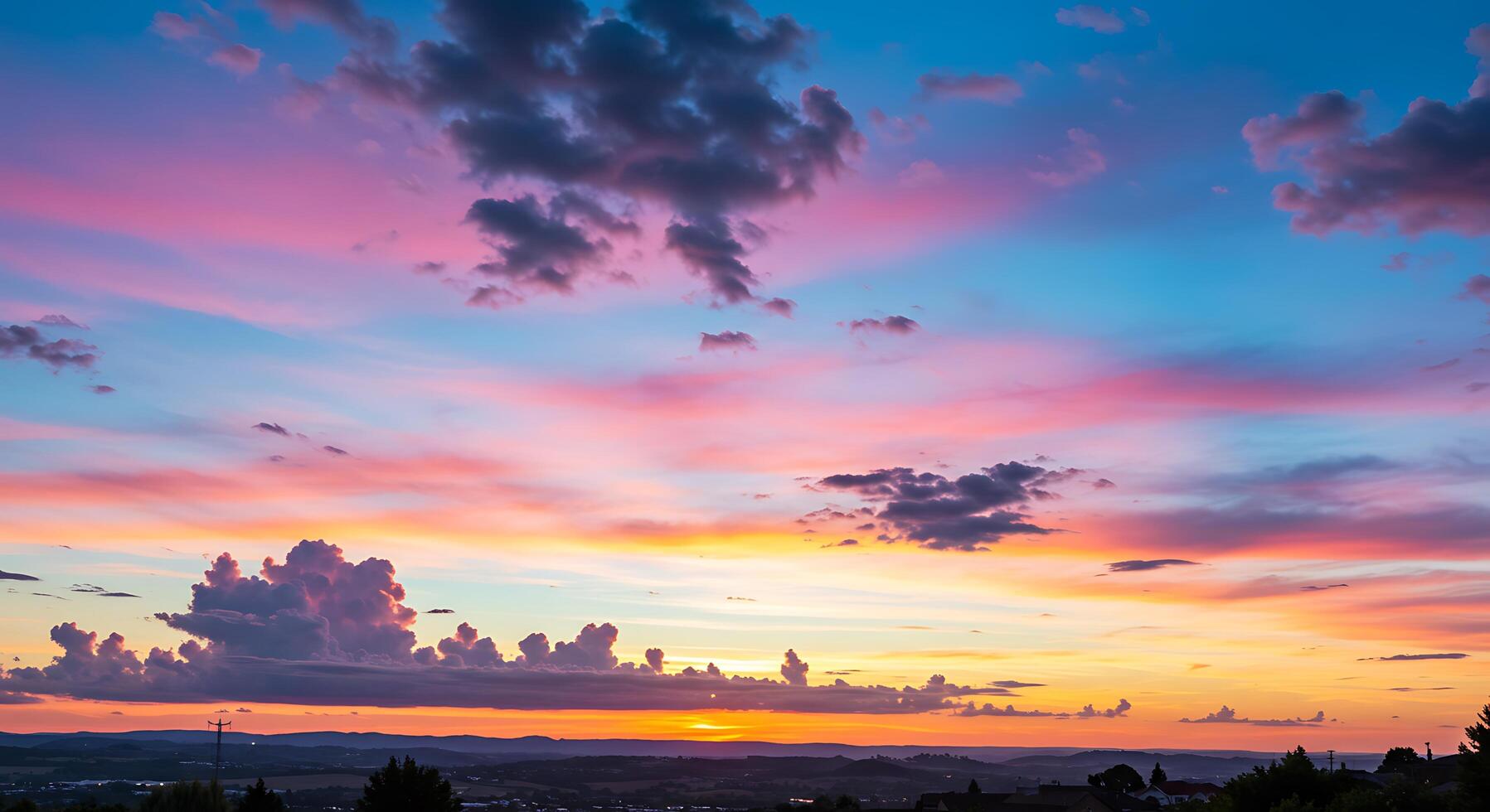 A colorful sunset over a city with a plane flying in the sky photo