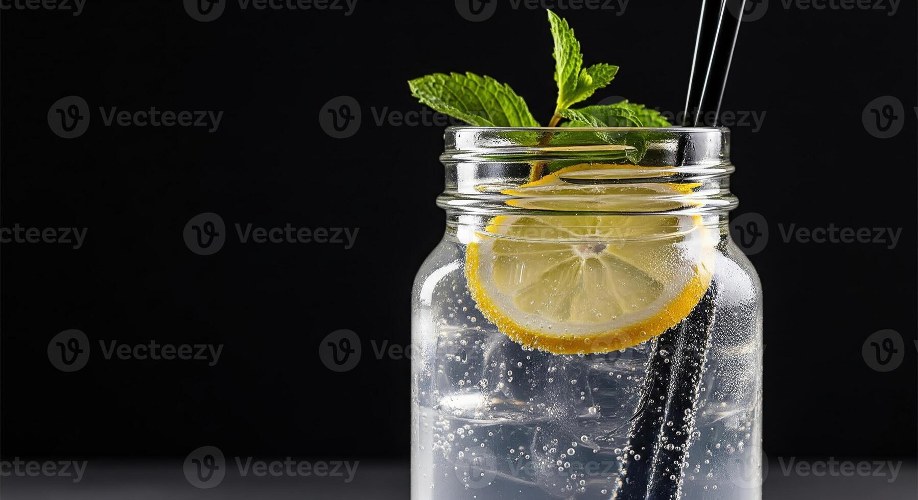 A glass jar with a lemon and a straw photo