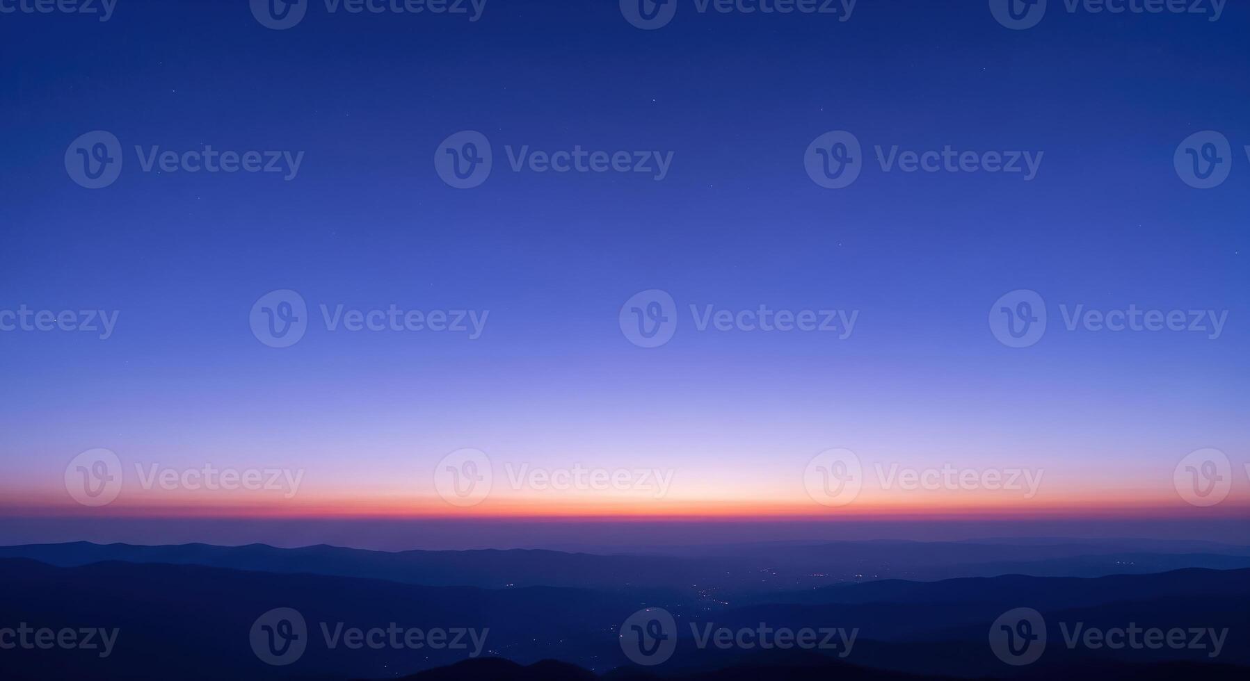A blue sky with a purple sunset over mountains photo