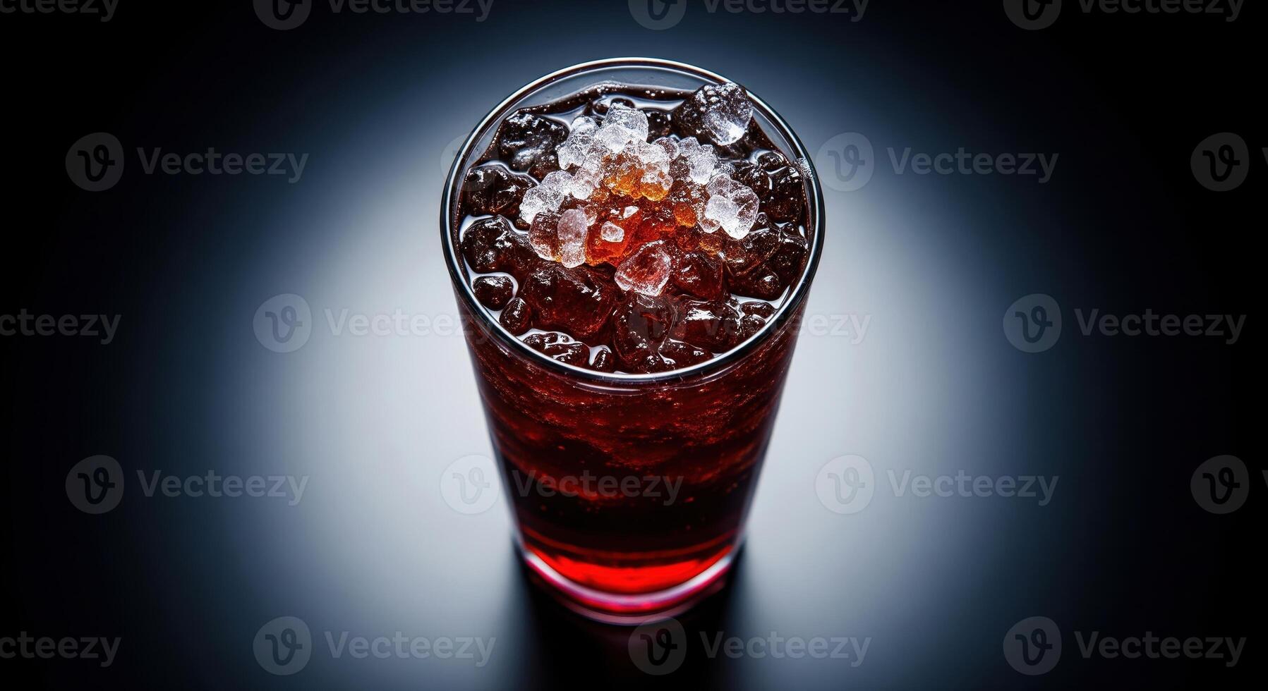 A glass of red liquid with ice on top photo
