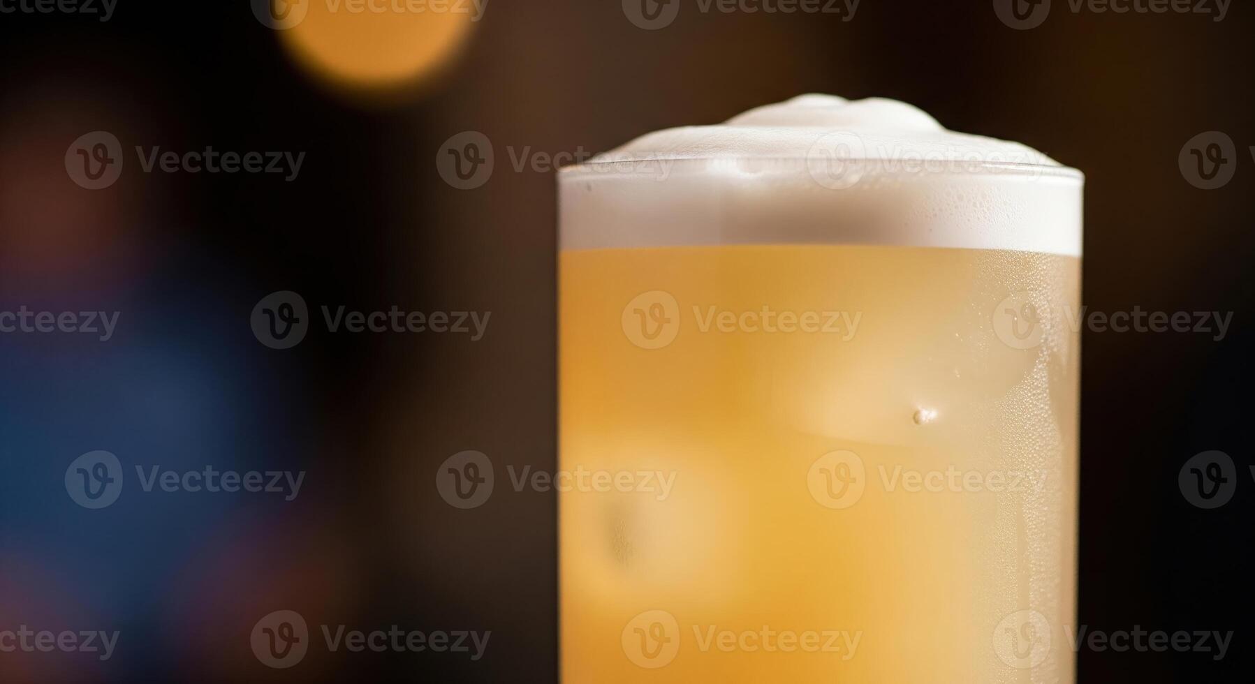 A tall glass of beer with foam on top photo