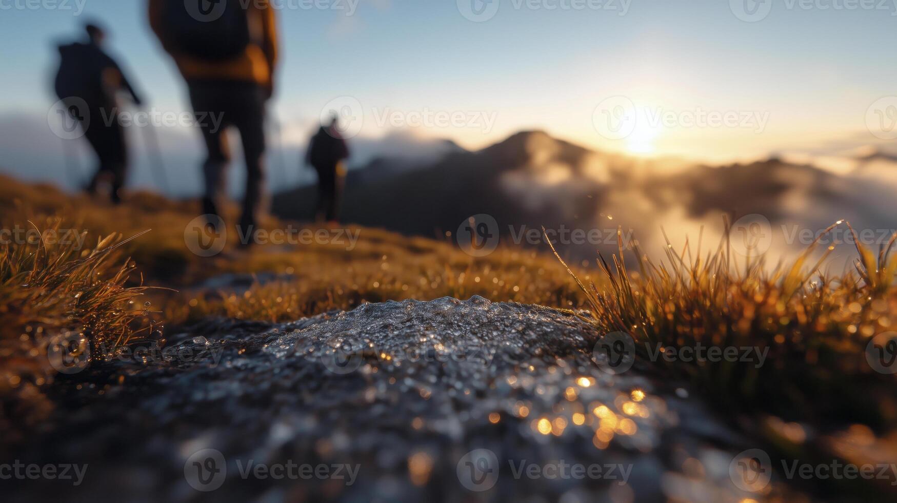 Three people hiking on a mountain at sunset photo