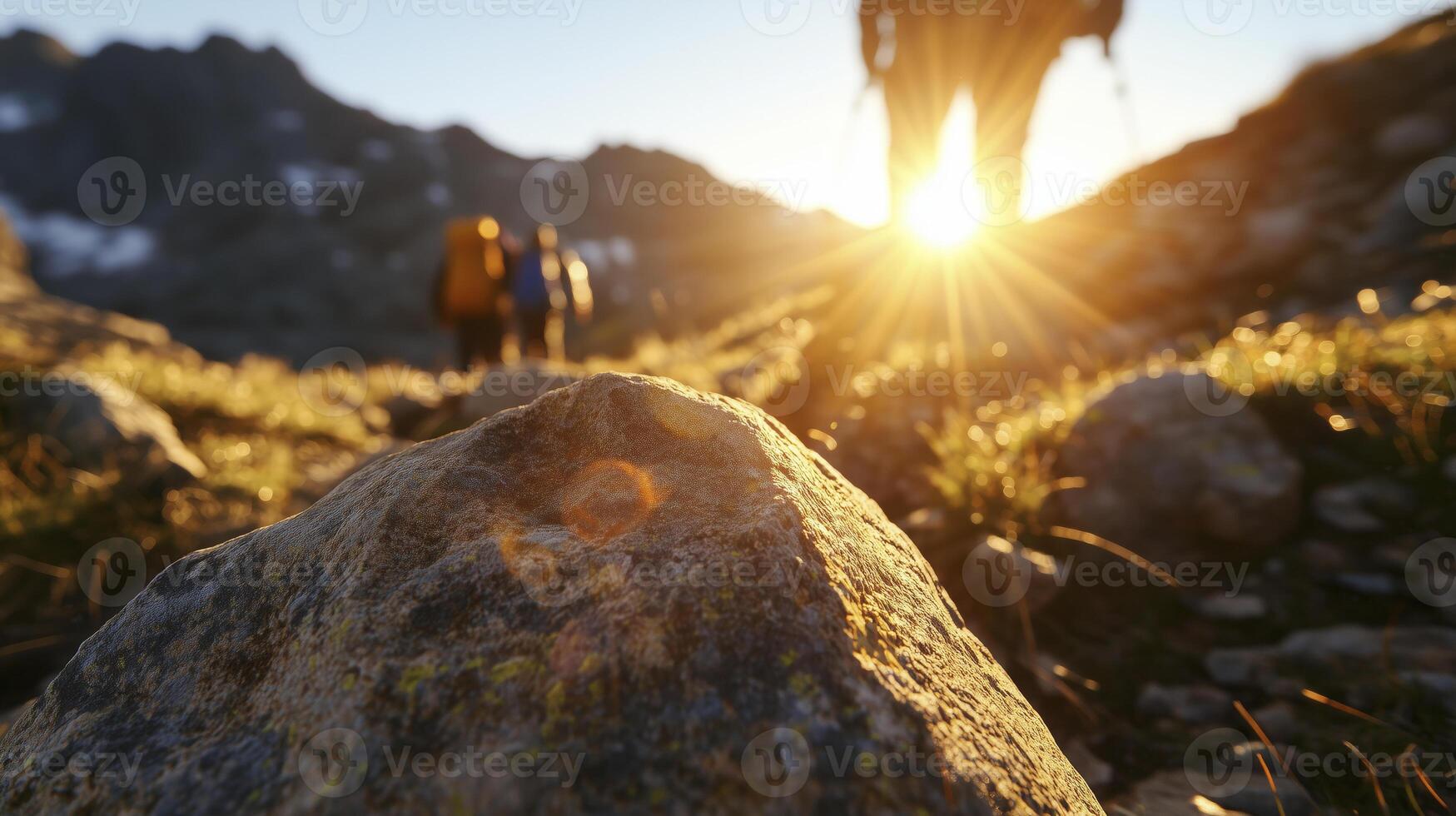 close-up of hikers traversing a sunlit mountain trail during golden hour photo