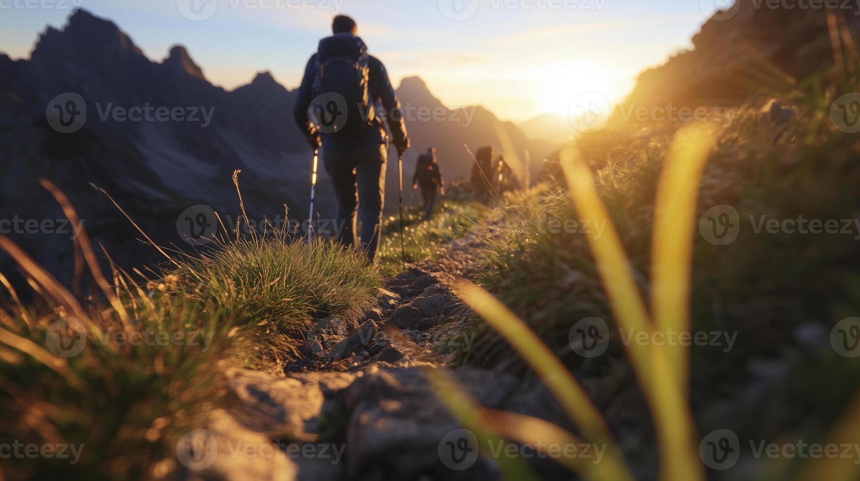 Hikers hiking in the mountains at sunset photo