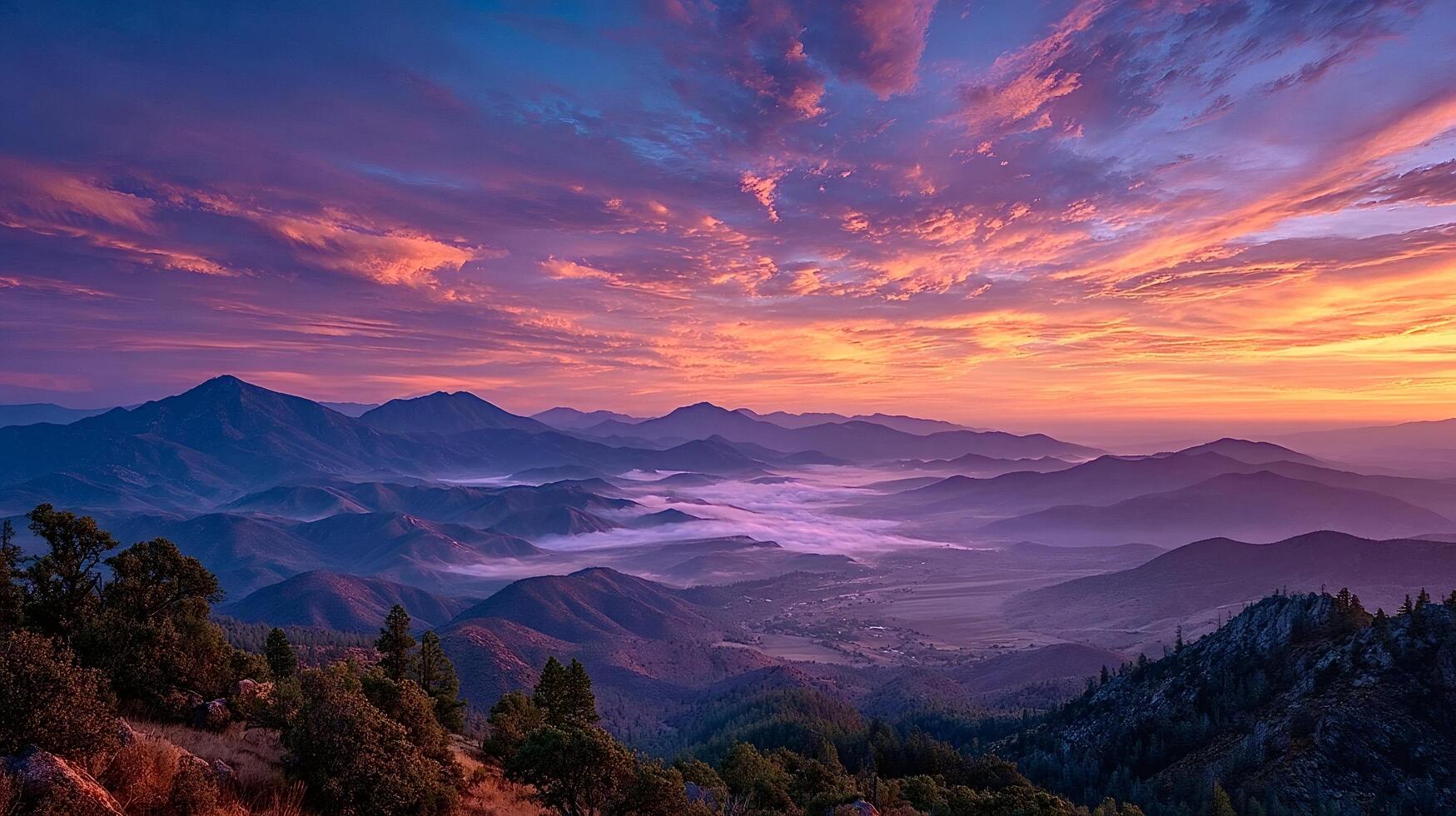 Sunrise illuminating foggy mountain valley with colorful sky photo