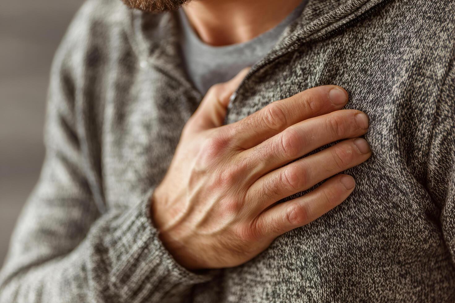 Mans hand on chest, showing pain or discomfort photo