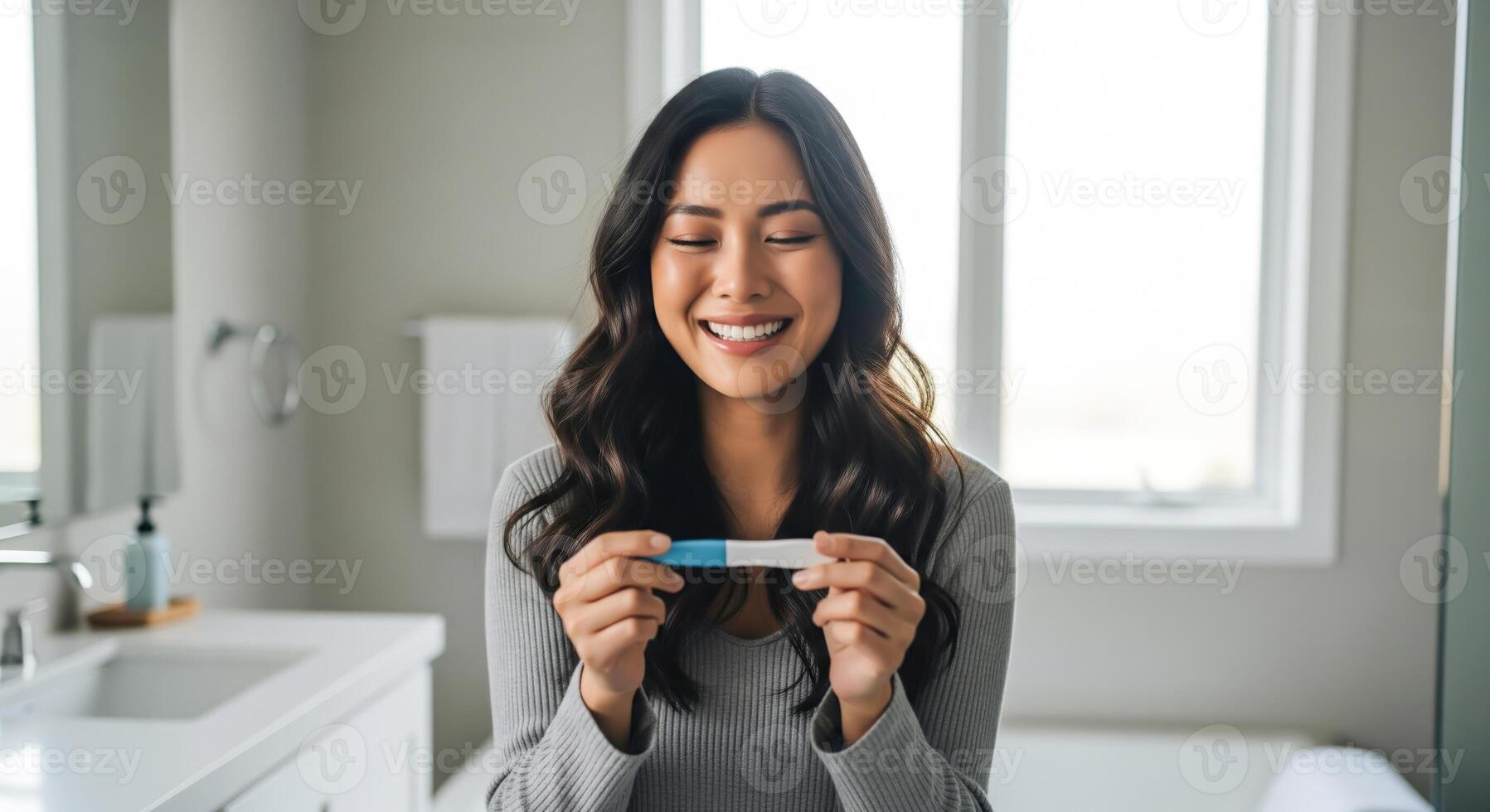pregnant woman holding a pregnancy test with a joyful expression... photo