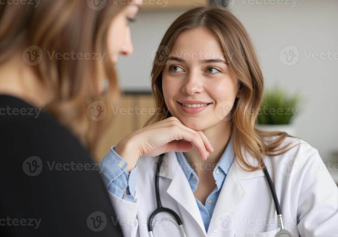 Smiling female doctor listening carefully to her patient during medical consultation photo