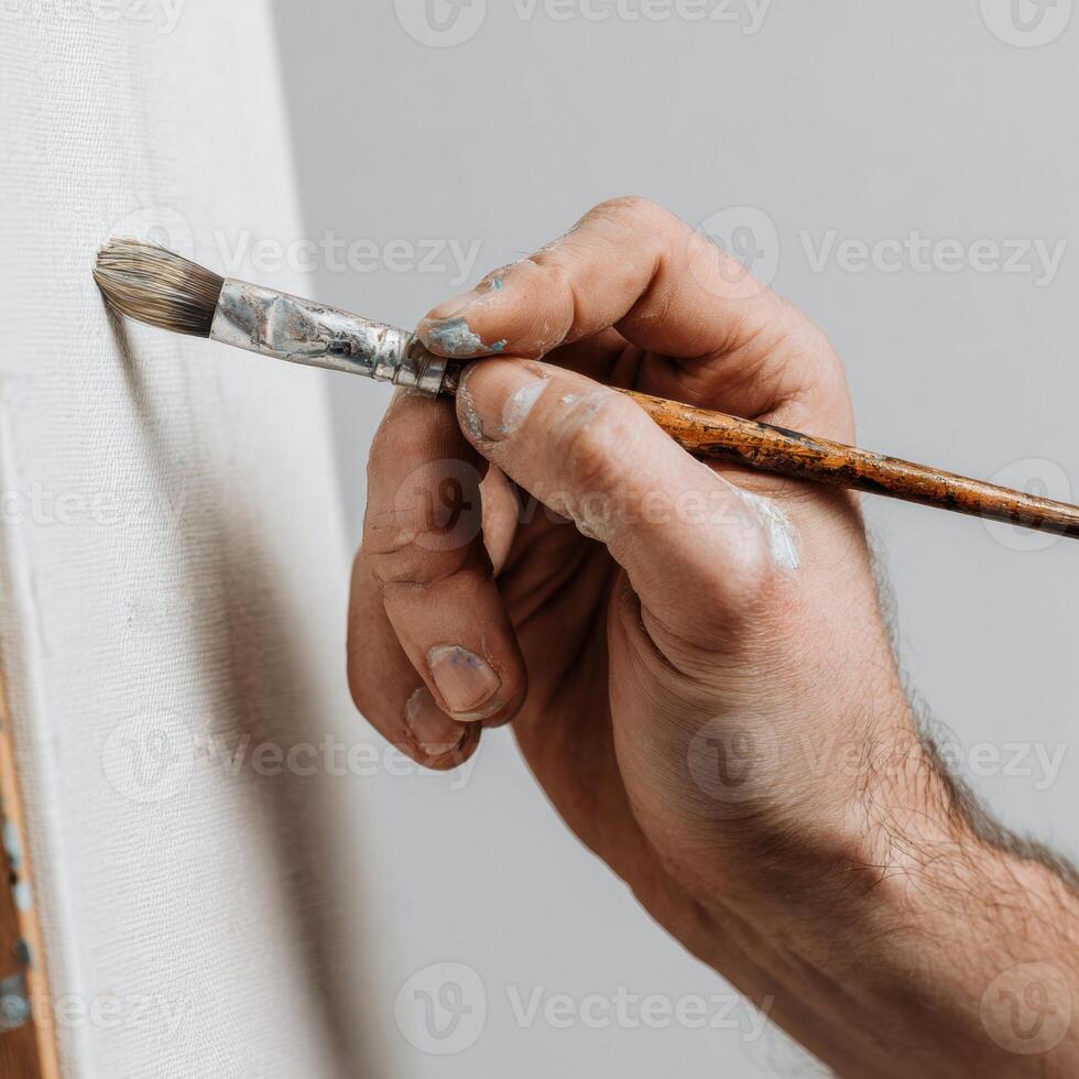 A person holding a brush and painting a canvas photo