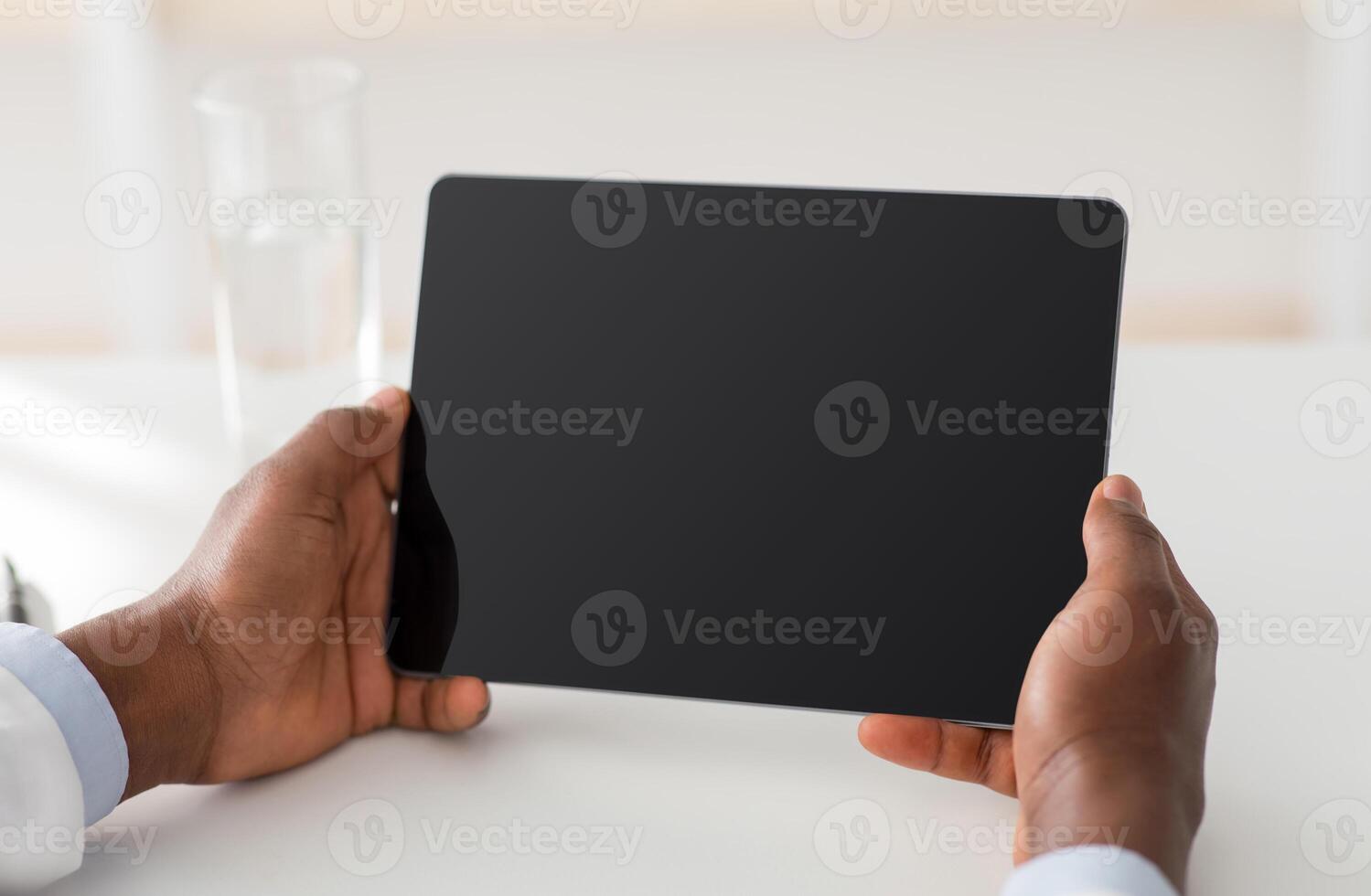 Technology for treat. Unrecognizable african american doctor using digital tablet with blank screen, empty space, mockup for ad. Male therapist sitting at workplace in office, closeup, crop photo
