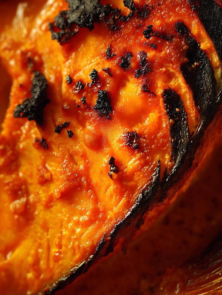 Close up of Grilled Salmon with Charred Edges and Orange Glaze. A detailed image showcasing the texture and vibrant color of the cooked fish. photo