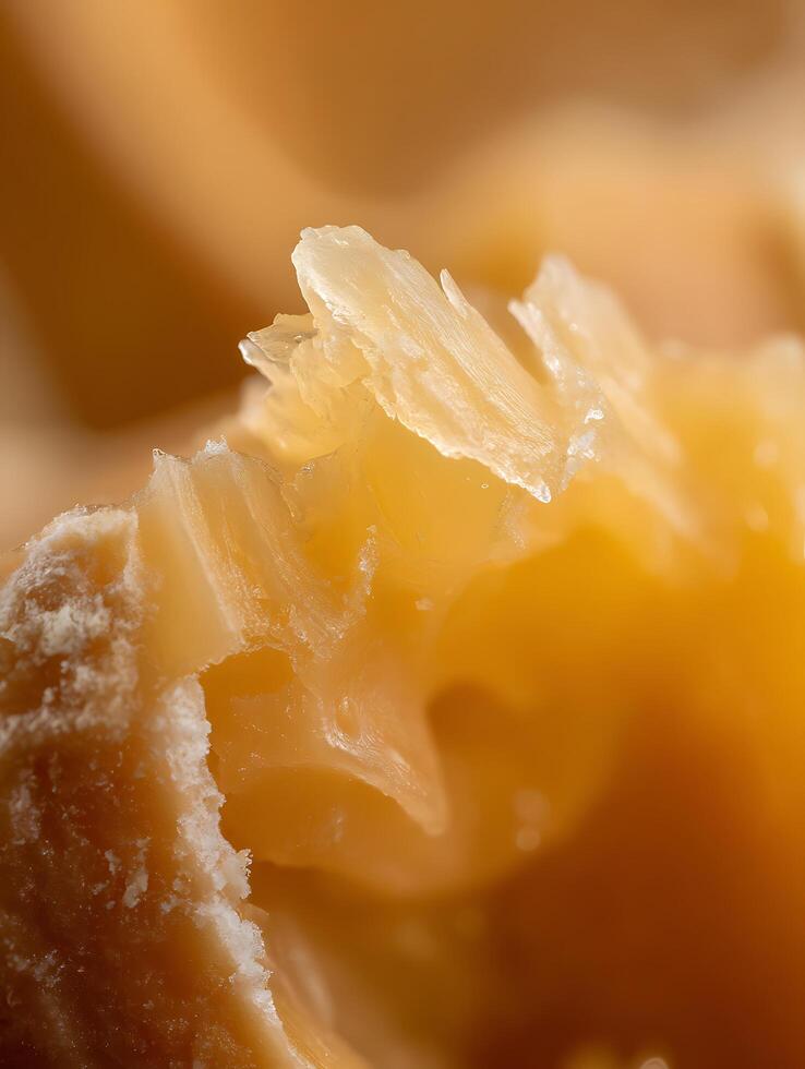Extreme close up of a broken caramel candy, revealing its texture and golden color. photo
