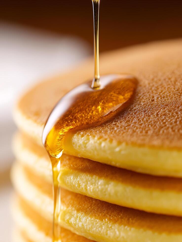 Golden Syrup Drizzling onto a Stack of Fluffy Pancakes. photo
