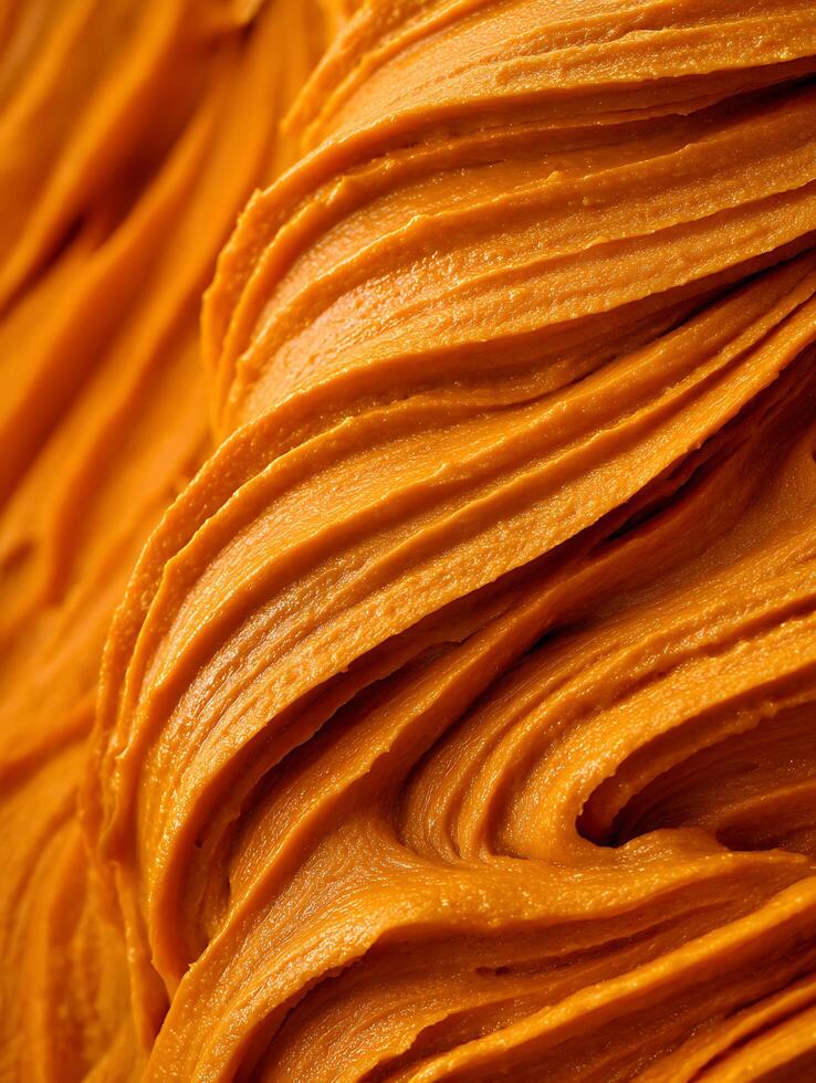 Close Up of Creamy Orange Food Texture, Swirled Pattern. photo