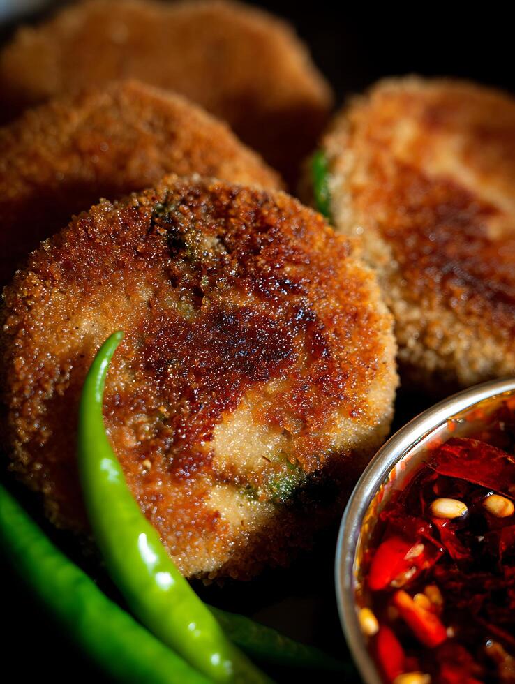 Close up of Crispy Fried Cutlets with Spicy Chili Dip and Green Chillies. photo