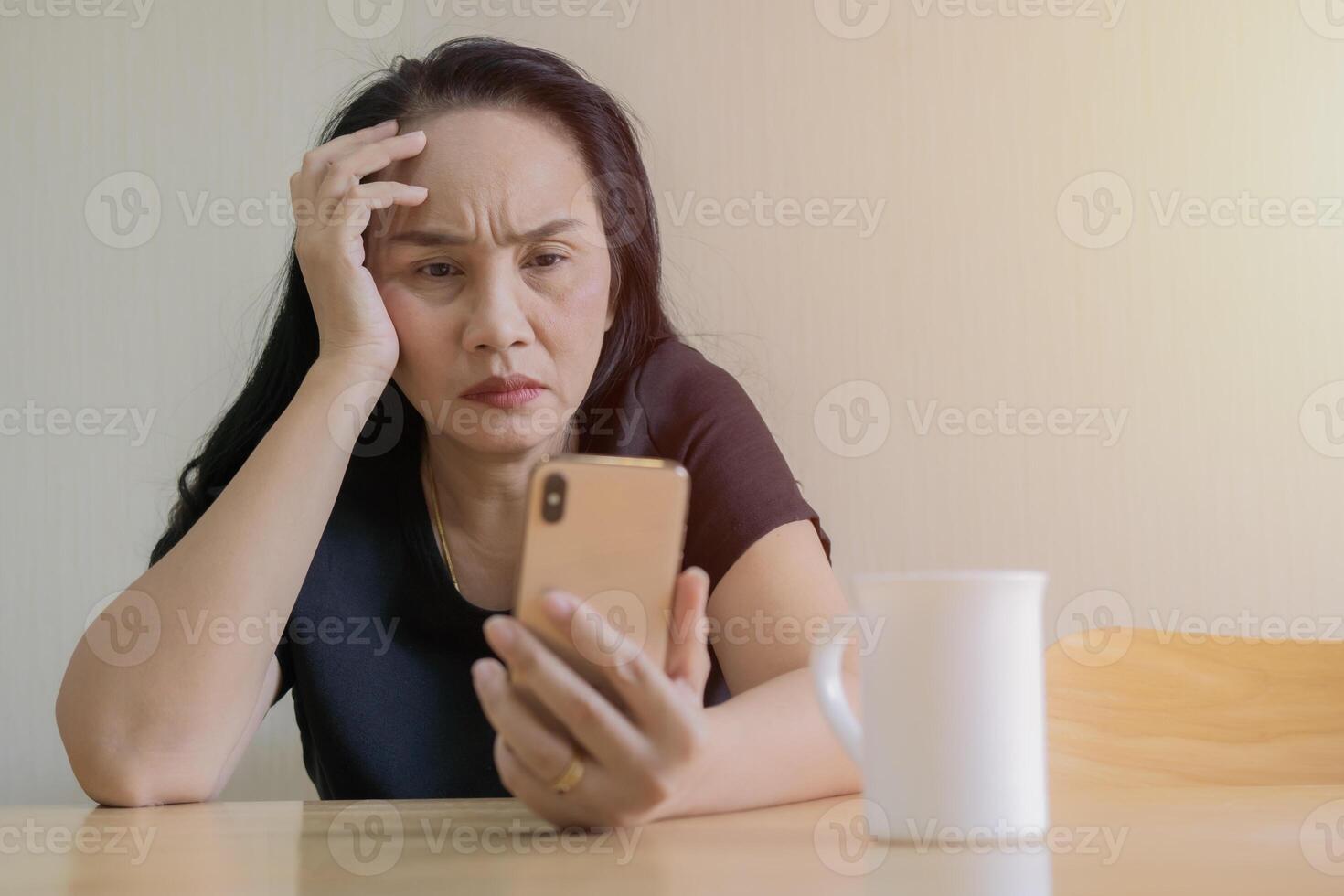 Upset confused woman holding smartphone, looking at mobile phone screen photo