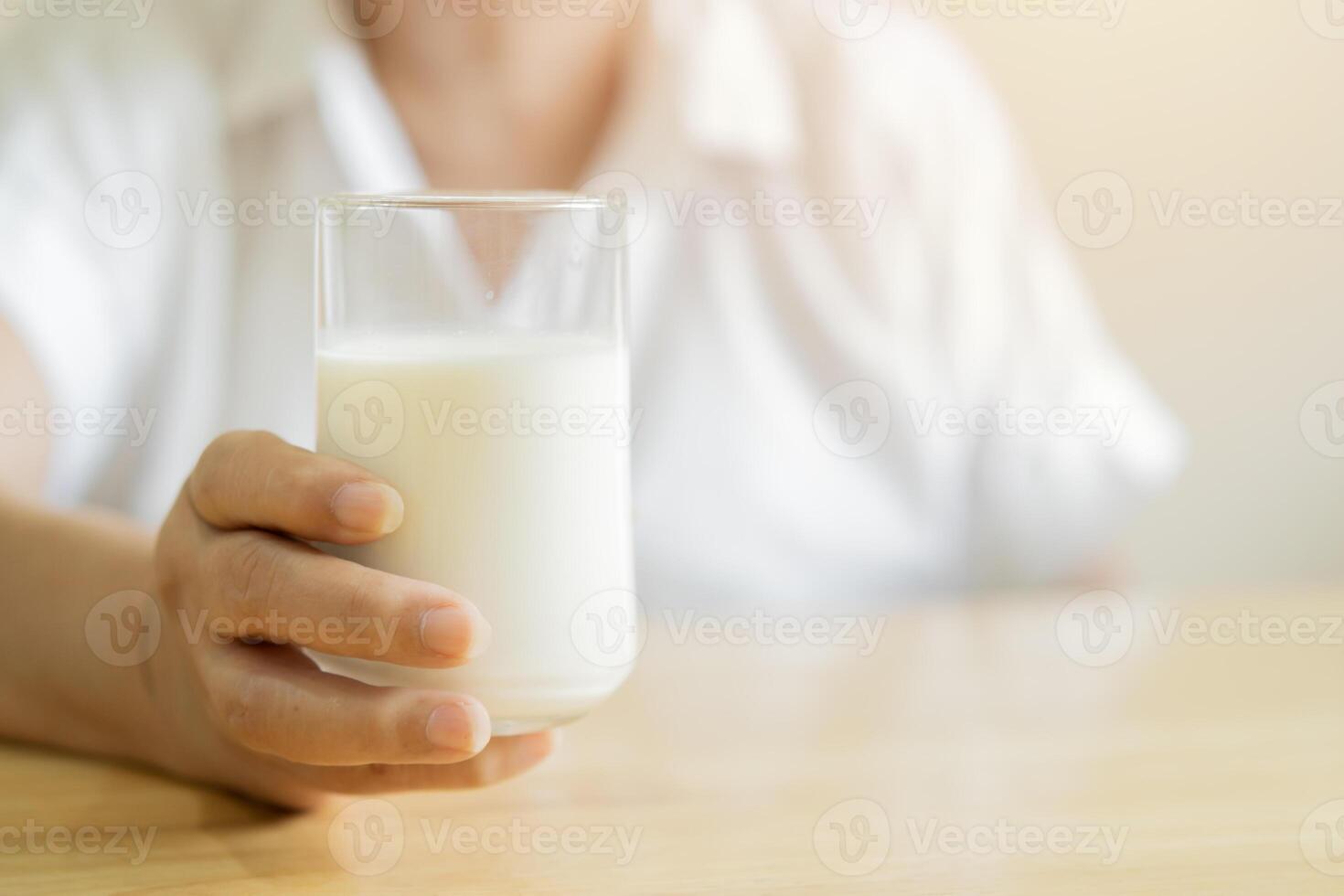 Senior woman holding glass of milk with copy space. Health care concept. photo