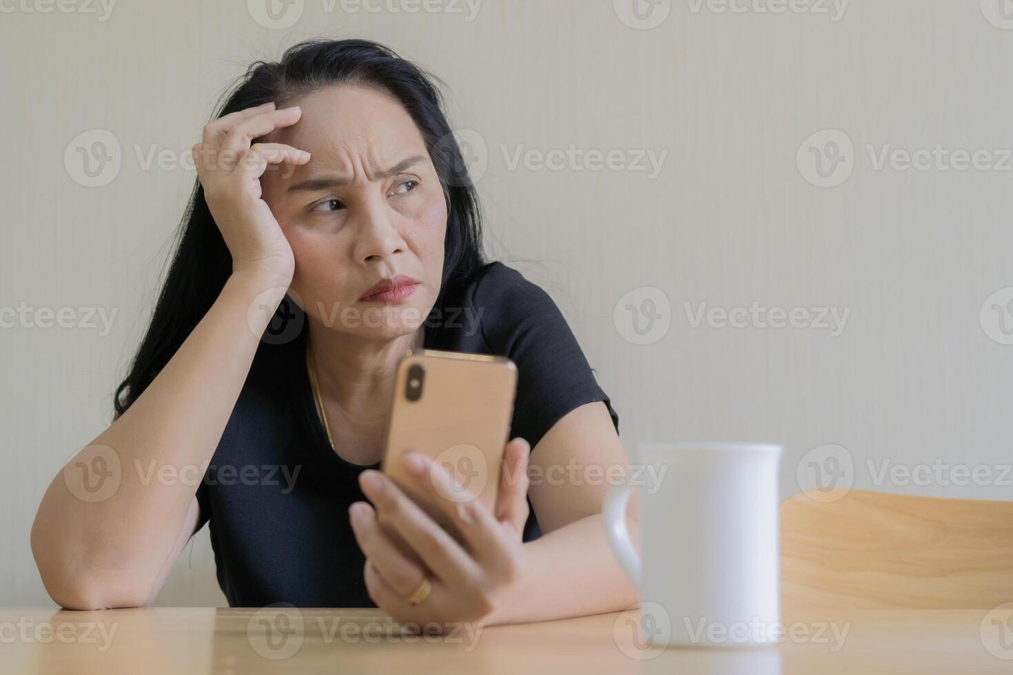 Waiting for his call. Depressed black hair woman looking at outside with sad face, sitting on couch at home photo