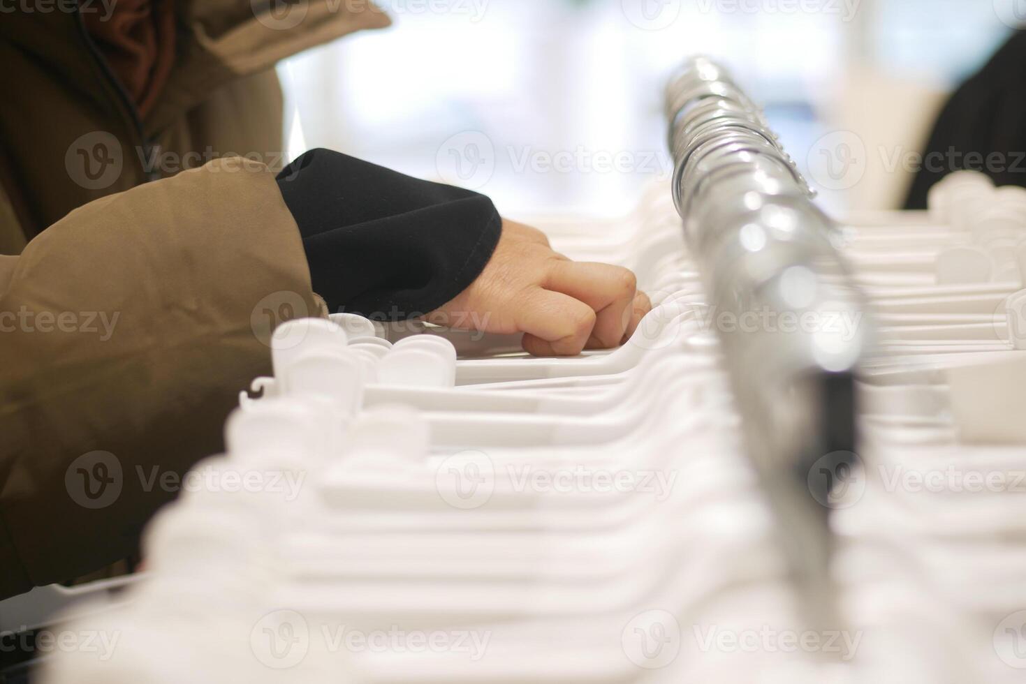 Selecting hangers in a retail store during shopping time photo