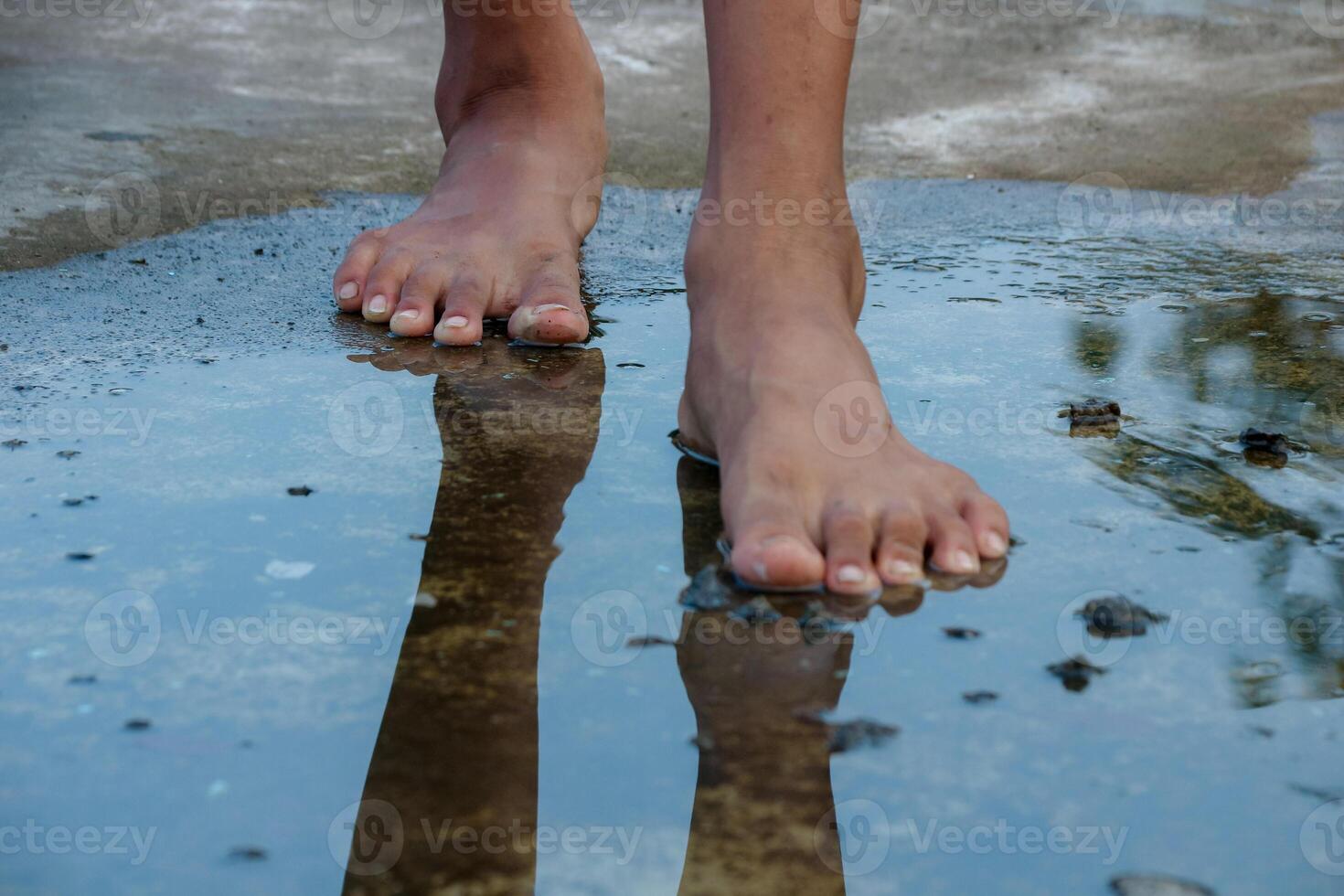 Bare Feet Walking Through Puddle with Reflections photo