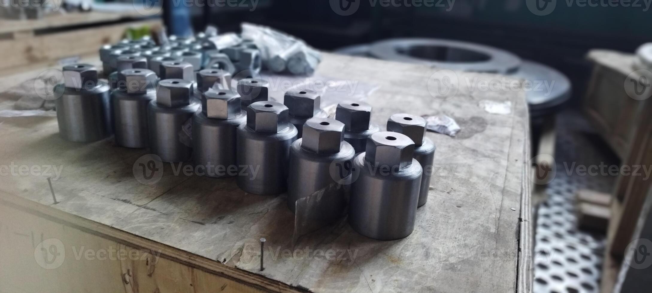 Cap nuts. Close-up manufactured metal parts with a hexagonal head. Industrial fasteners on a wooden surface. Metal components with a hexagonal head. Industrial parts arranged on a wooden surface. photo