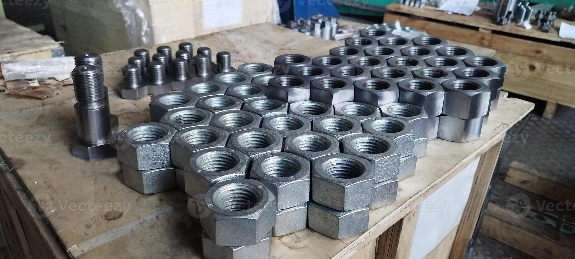 Image of the nuts and bolts. Close-up of new metal nuts and bolts. Industrial fasteners with a blurred workshop background. Metal hardware in a manufacturing setting. Machine nuts and bolts. photo