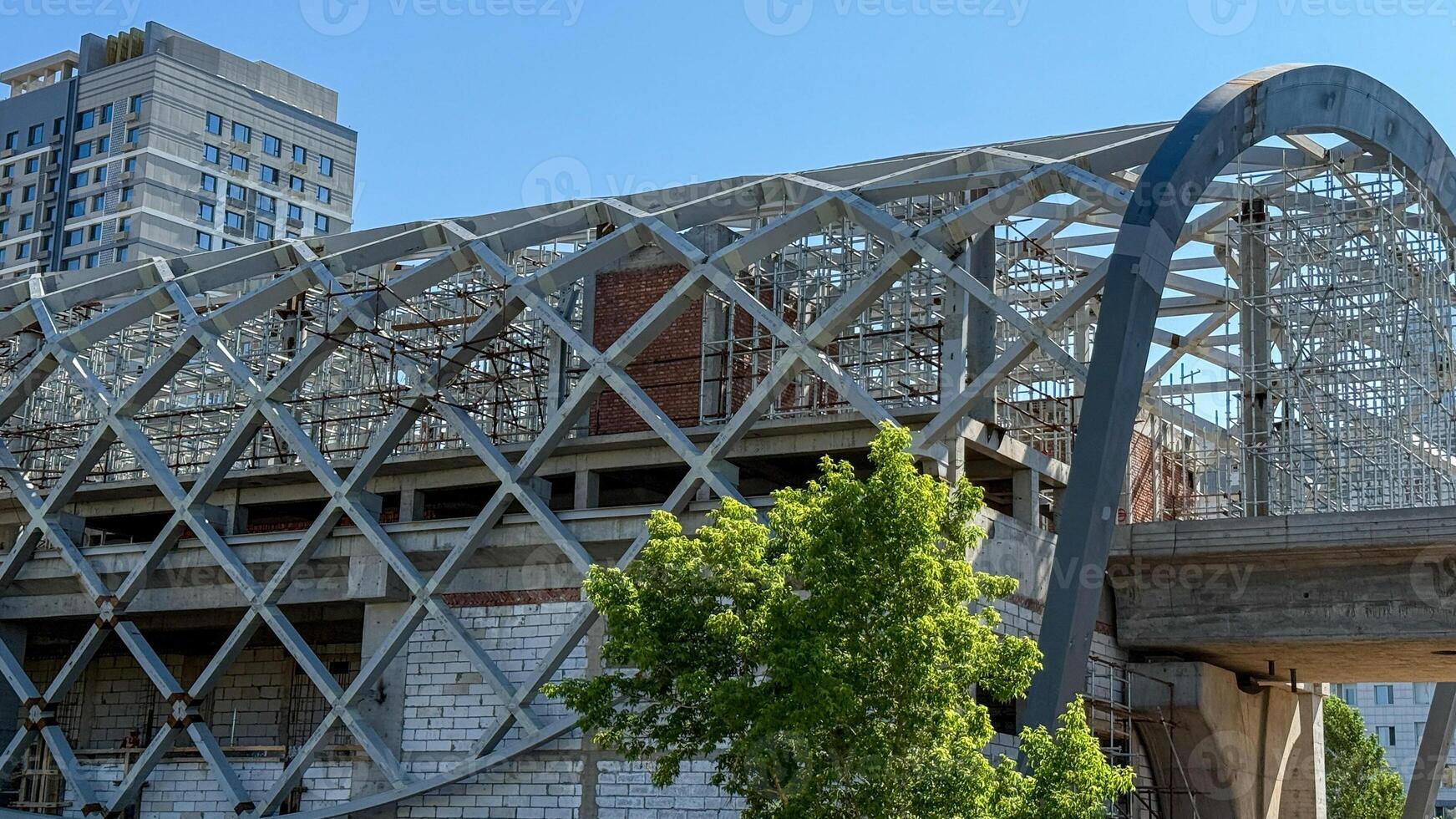 Intricate latticework weaves urban daydreams, echoing Labor Days industrious spirit in a cityscapes skeletal hug photo