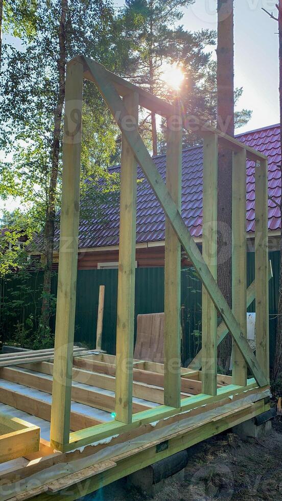 Rays of sunlight pierce through budding timber frame, whispering tales of eco homes and solstice celebrations in rustic harmony photo