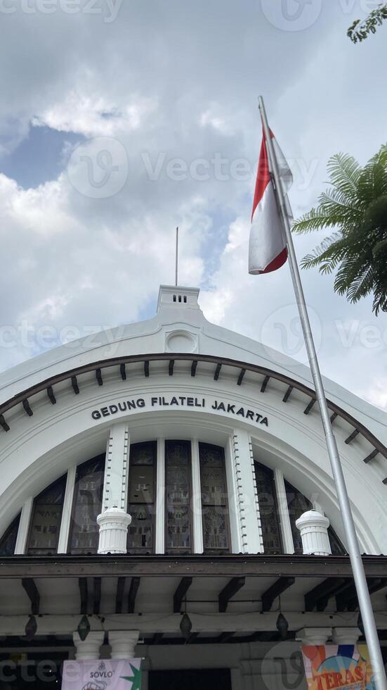 Portrait View of Jakarta Filateli Building with Indonesian Flag photo