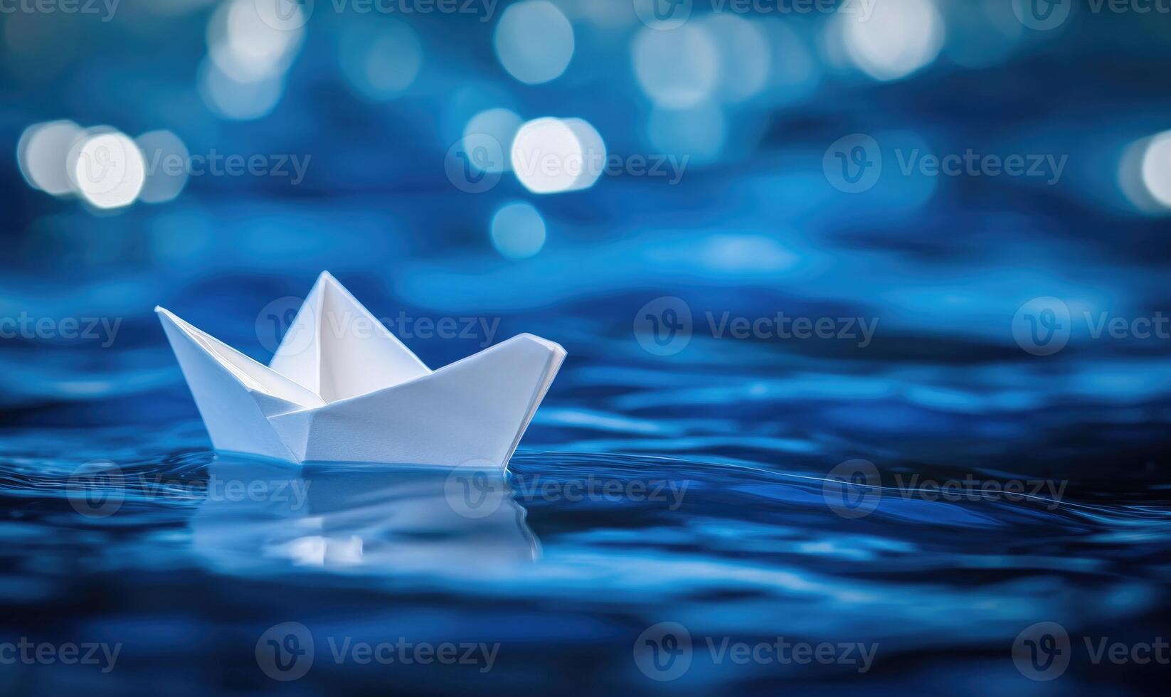 Paper boat on blue water photo