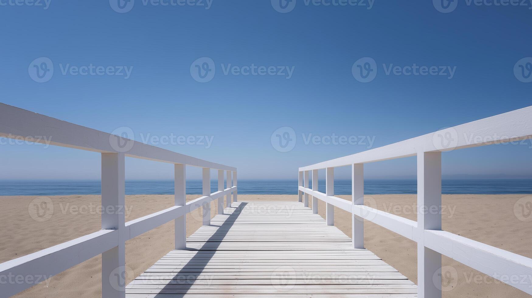 Wooden boardwalk extends towards the calm ocean, framed by white railings, leading to a serene beach under a clear blue sky, inviting relaxation and tranquility photo