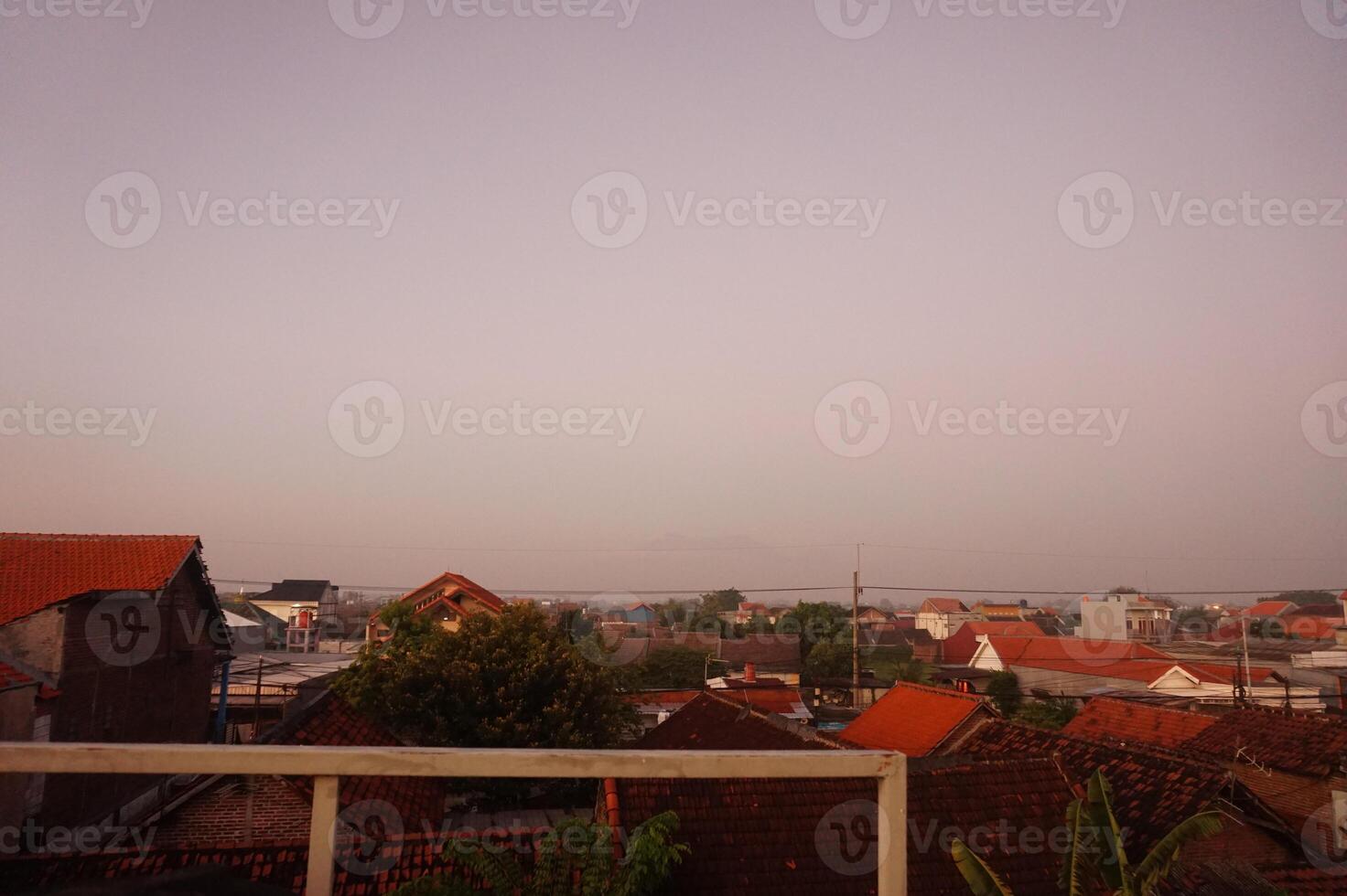 A view of the rooftops of a town at dusk photo
