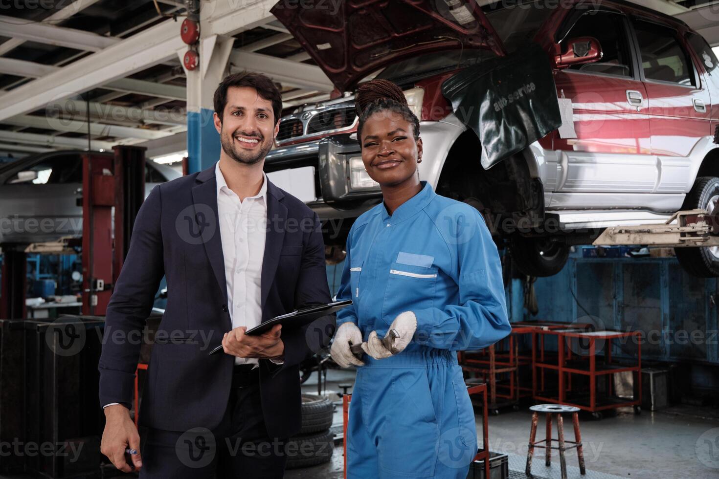 Portrait of professional partner, Latino male manager, and Black female mechanic smile, cheerful, cooperate service claim business, car fix warranty and maintenance at auto garage station industry. photo