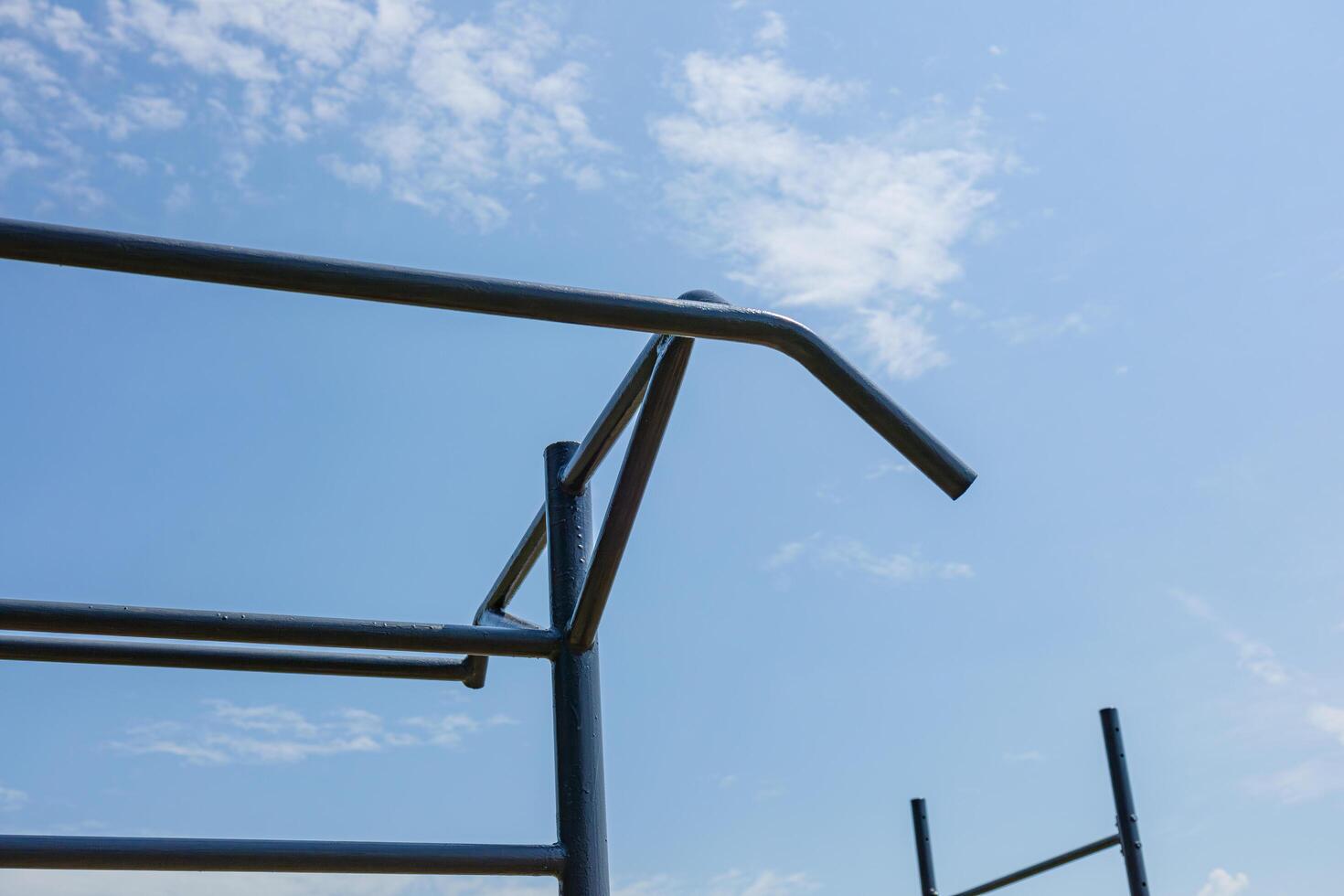 Empty parallel bars set in an outdoor gym, perfect for workout enthusiasts seeking an active lifestyle under a bright sky photo