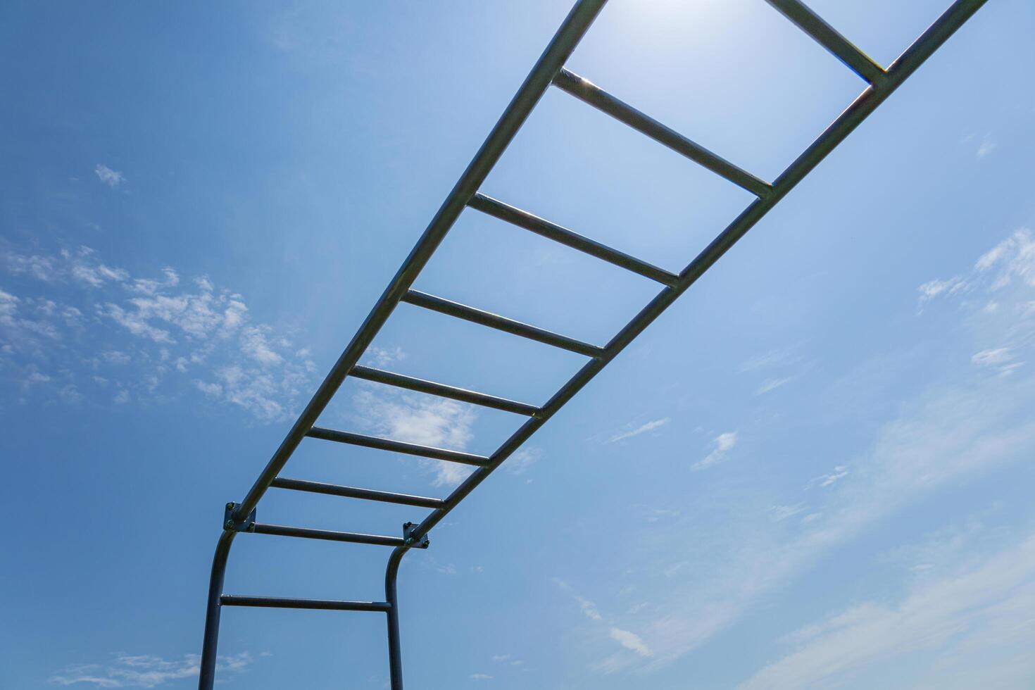 Rustic gym apparatus set against a vibrant blue sky encourages outdoor exercise and an active lifestyle for all ages photo